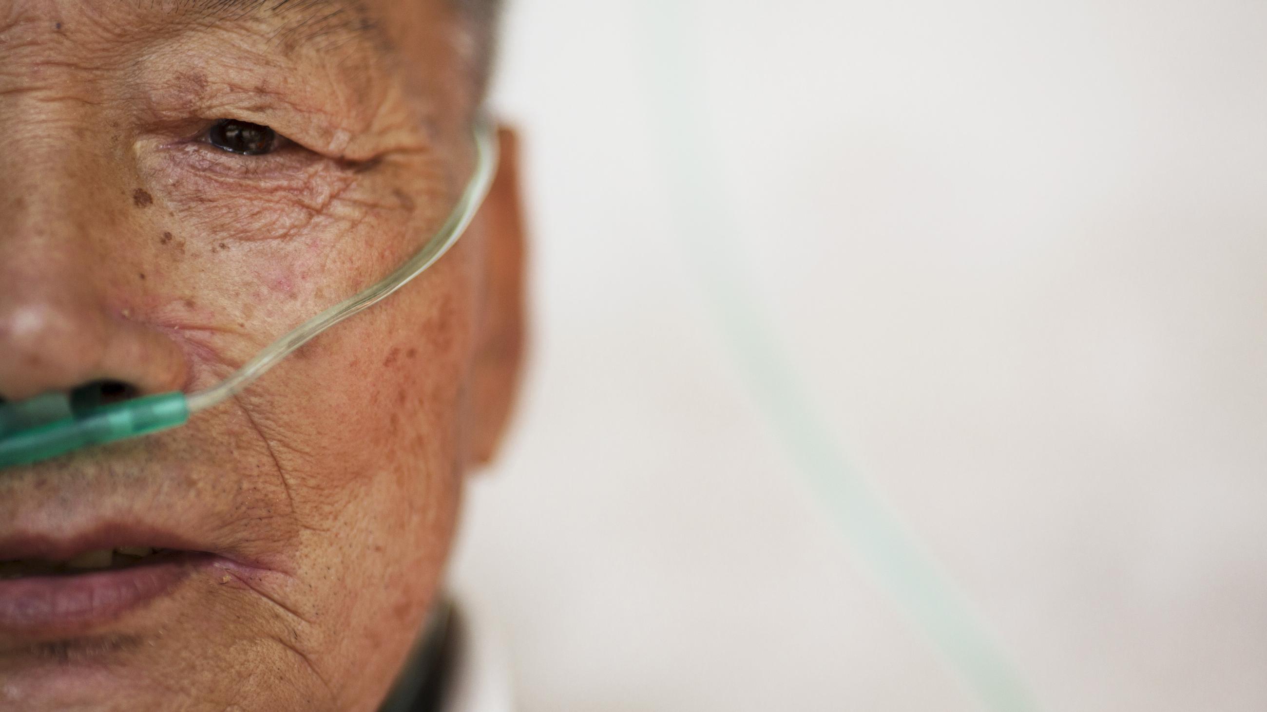 Hu Hushen, a 78 year old former miner, breathes using a nasal cannula for oxygen supply outside his room at Yangjia Hospital in Wuyi County, Zhejiang Province, China October 19, 2015.