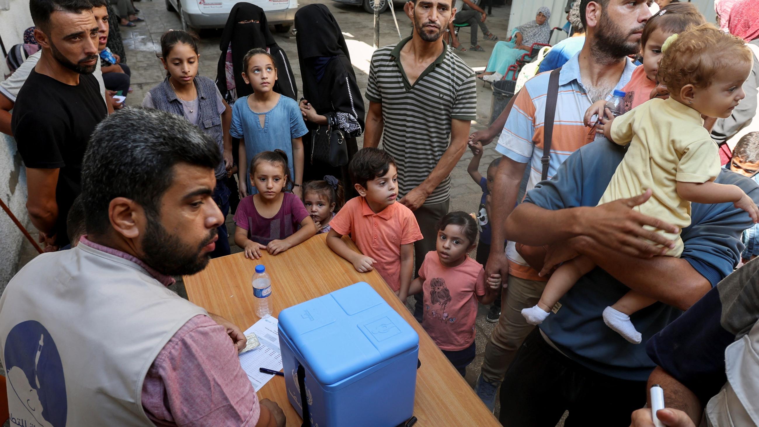 Palestinian children, accompanied by parents, wait to be vaccinated against polio.