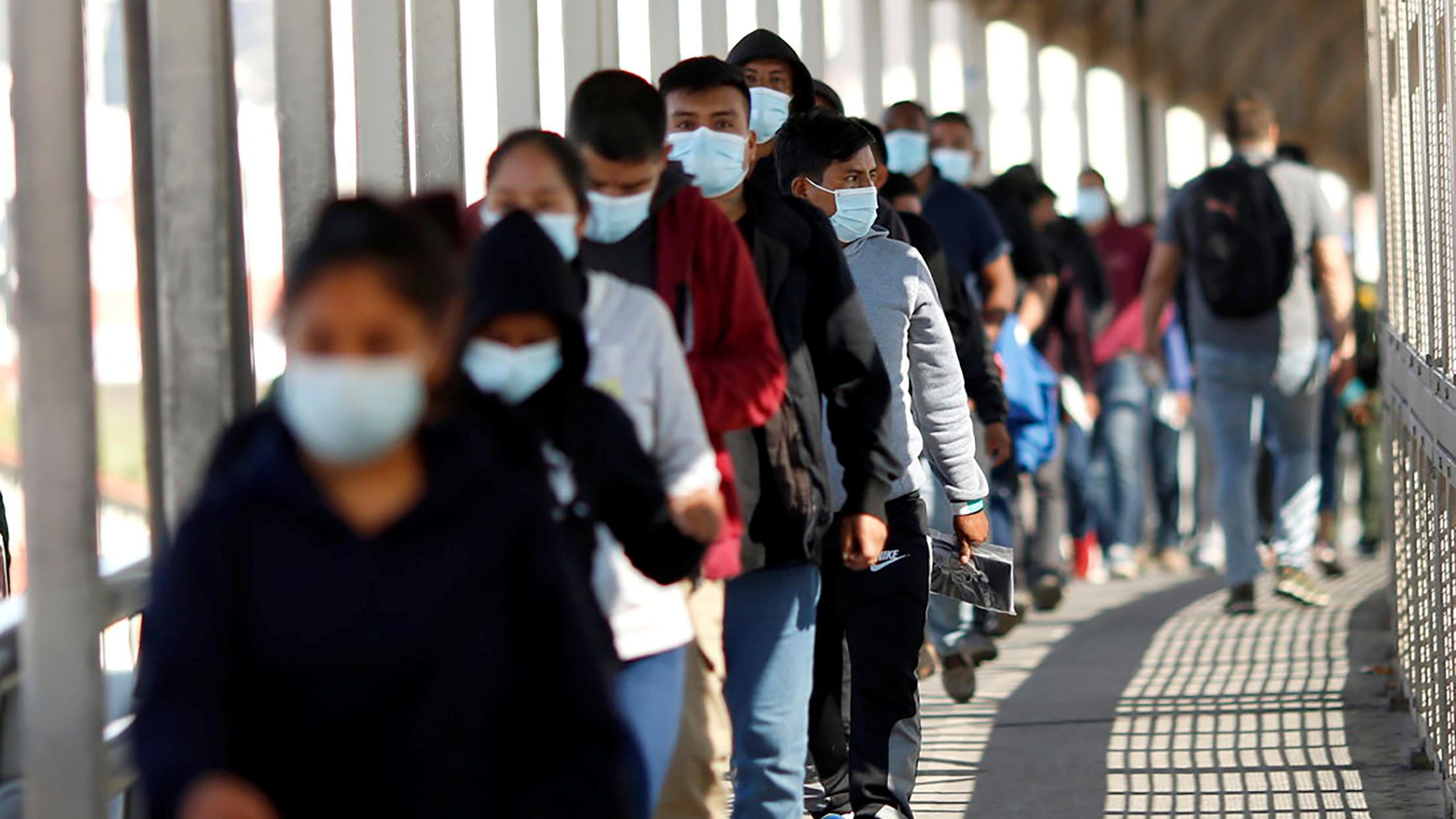 Migrants expelled from the U.S. and sent back to Mexico under Title 42, walk towards Mexico at the Paso del Norte International border bridge.