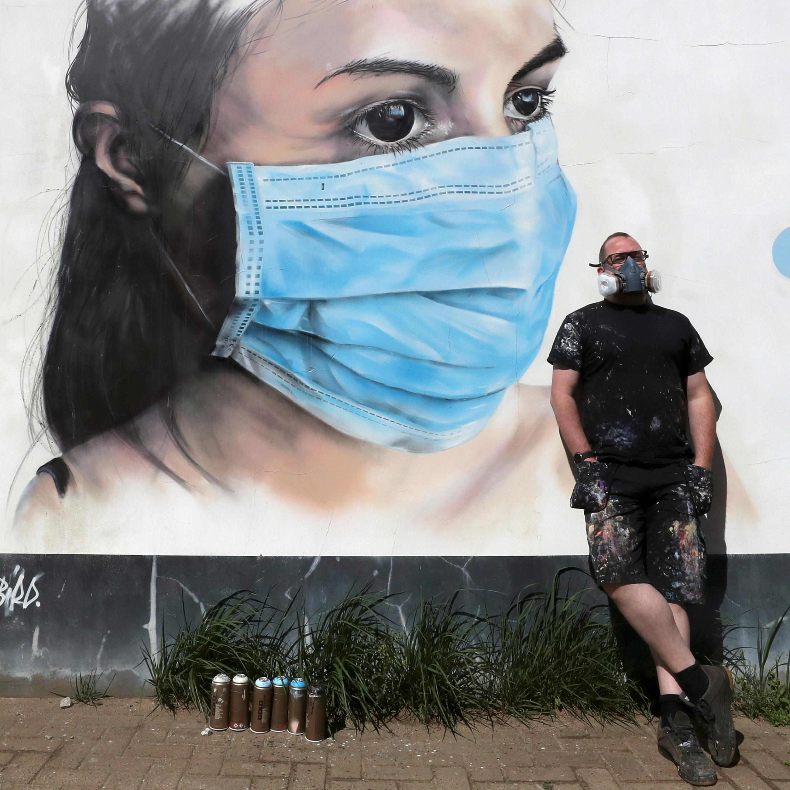 Artist Bram De Ceurt stands next to a work he created in support of medical staff during the COVID-19 outbreak, in Antwerp, Belgium, on April 30, 2020.