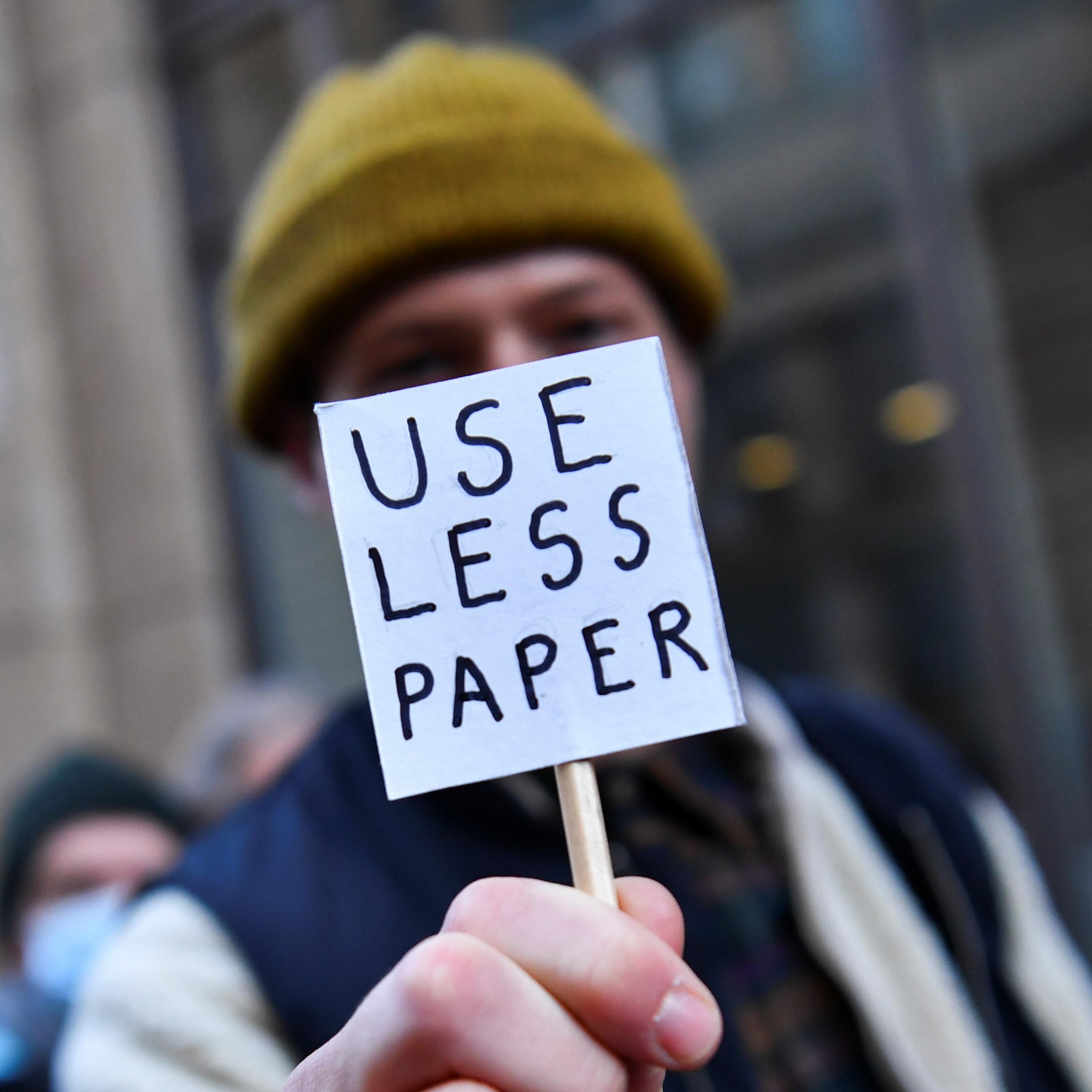 A person holds a small sign during a protest outside JP Morgan during the conference in Glasgow.