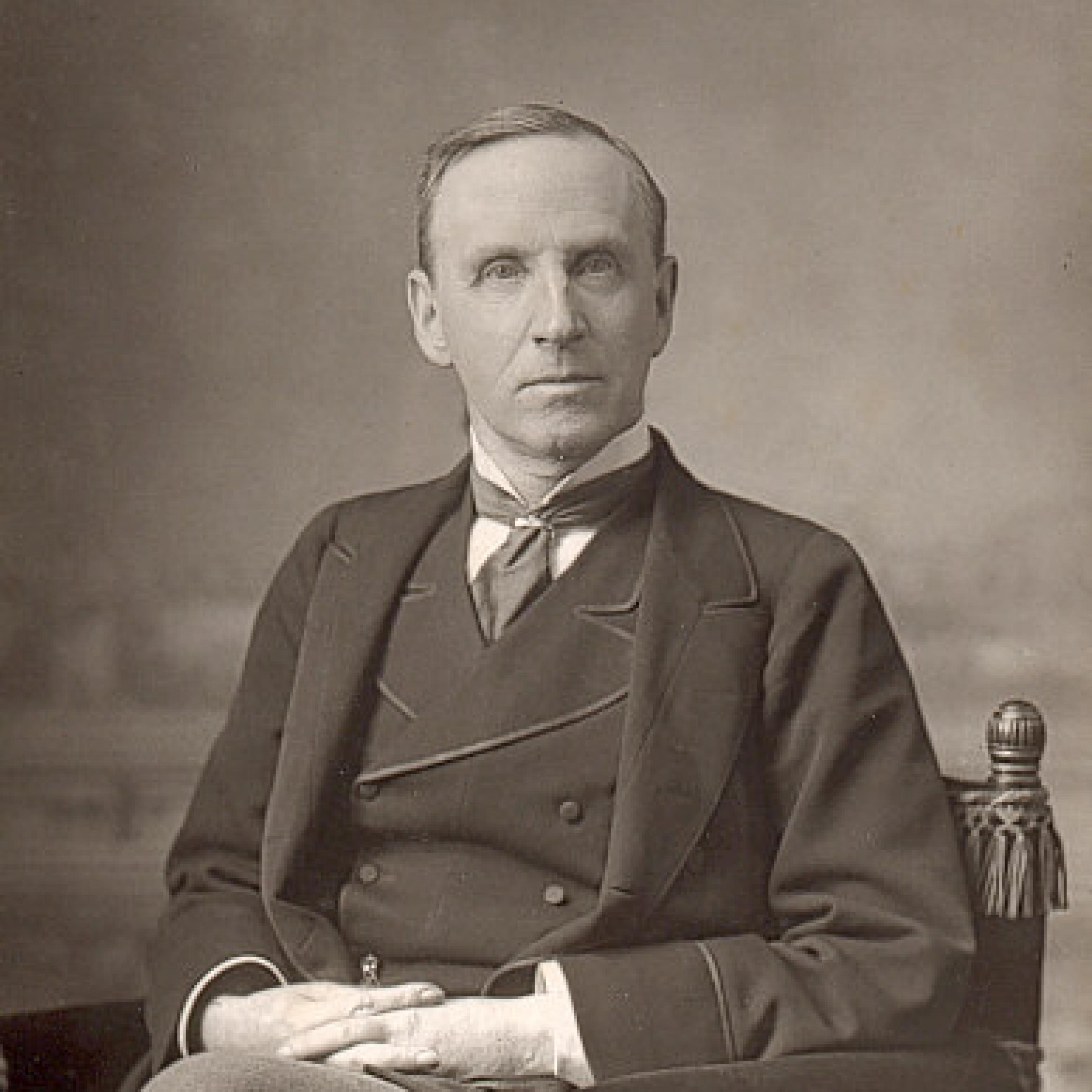 a black and white photo depicts John Morley, a fair-skinned englishman with short blond hair and light eyes