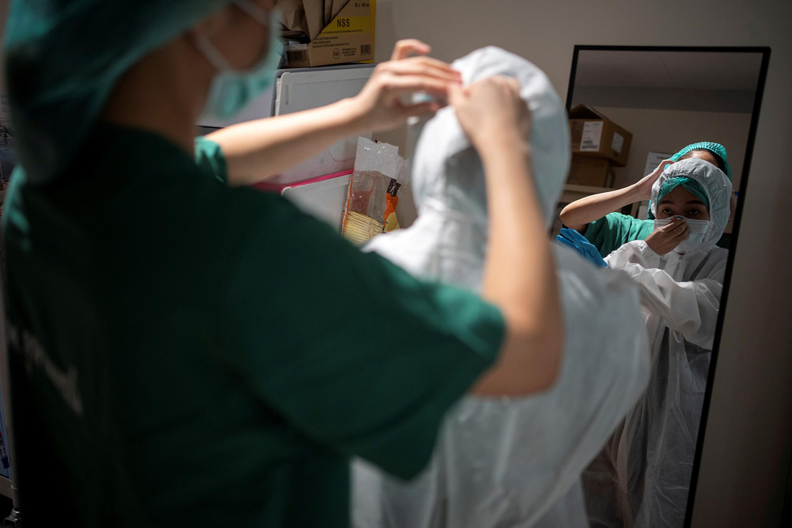 Nurse Tatsanee Onthong, 26, receives help putting on PPE before attending to a COVID-19 patient in the ICU at King Chulalongkorn Memorial Hospital in Bangkok, Thailand, on April 22, 2020. Picture shows a nurse being helped into her PPE. REUTERS/Athit Perawongmetha