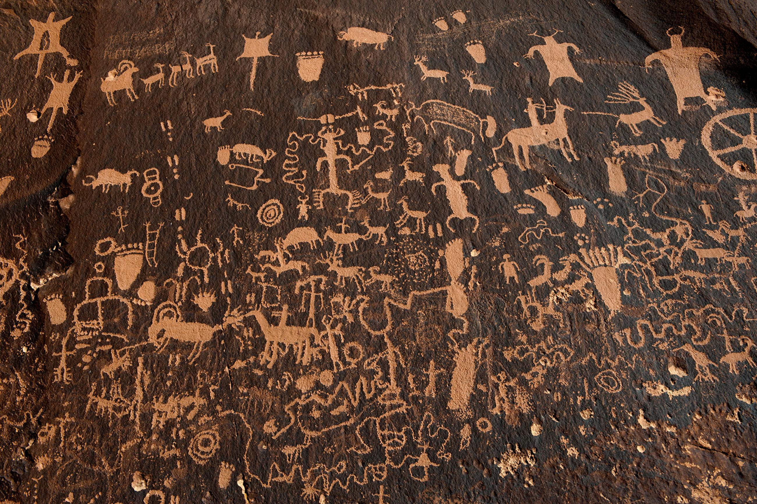 Hundreds of petroglyphs cover Newspaper Rock, in Bears Ears National Monument, Utah, next to the Naajo Nation, on October 29, 2017. The photo shows a dark rock face covered with hundreds of carved depictions of humans and animals. REUTERS/Andrew Cullen