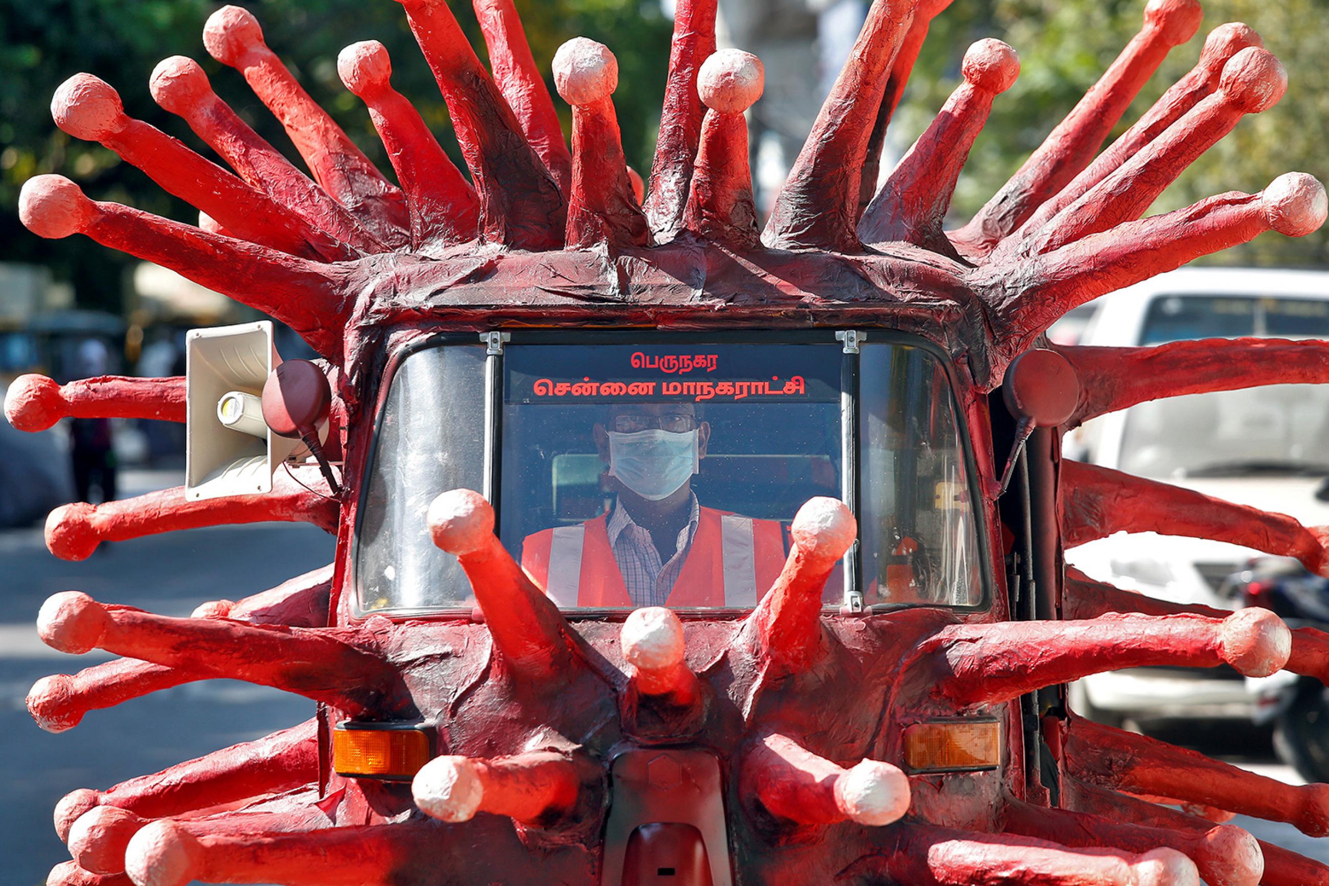 A man drives an auto-rickshaw depicting the coronavirus to create awareness about staying at home during a nationwide lockdown to prevent the spread of COVID-19—in Chennai, India, on April 23, 2020. The image shows a vehicle painted red and covered with crown spikes reminiscent of the virus, which appear to be made of paper mache. REUTERS/P. Ravikumar