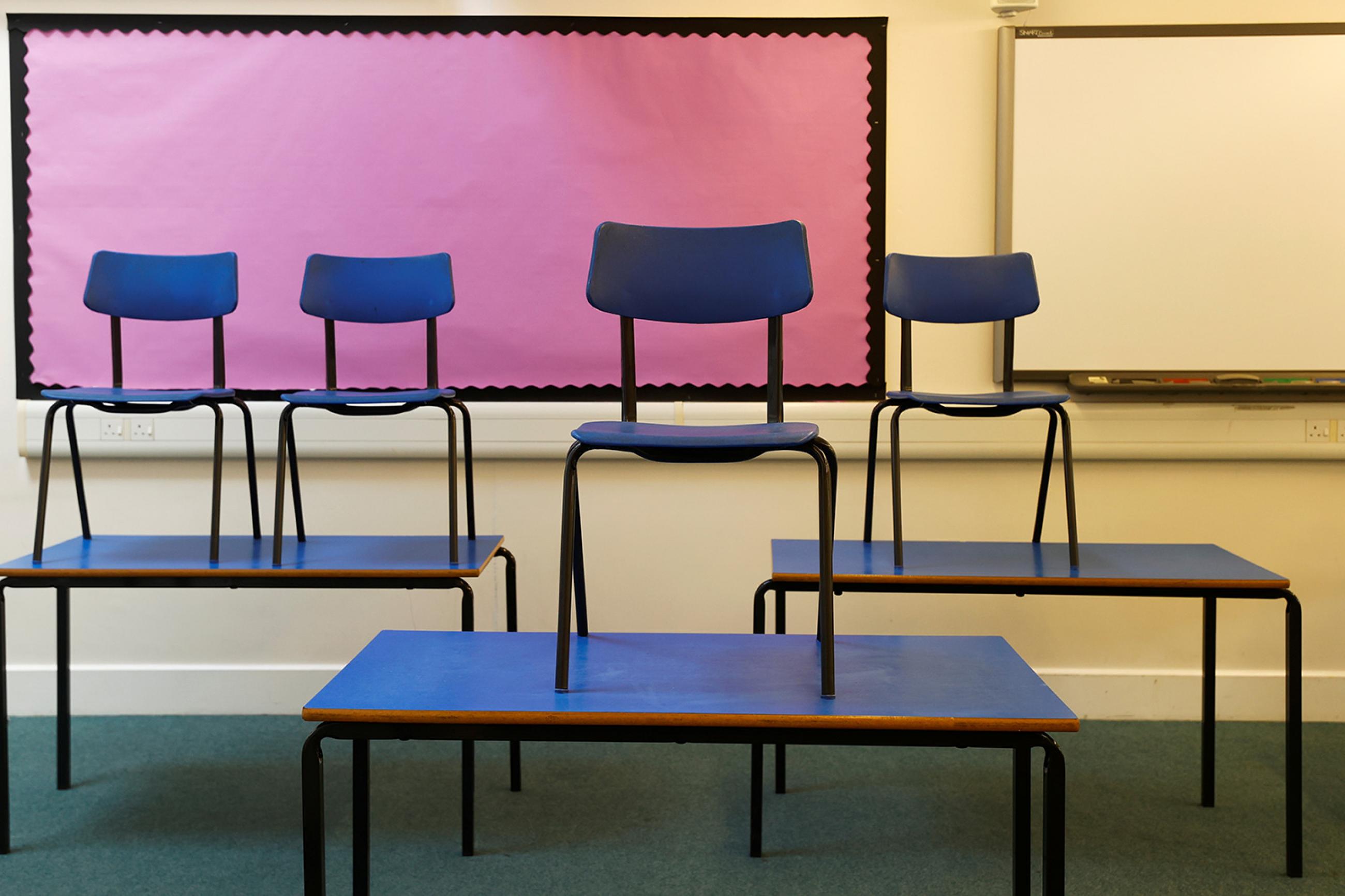 Chairs are pictured on top of tables in a classroom at Watlington Primary School during the last day of school, amid the coronavirus outbreak in Watlington, Britain, on July 17, 2020. The photo shows a number of tables with chairs stacked upon them. REUTERS/Eddie Keogh