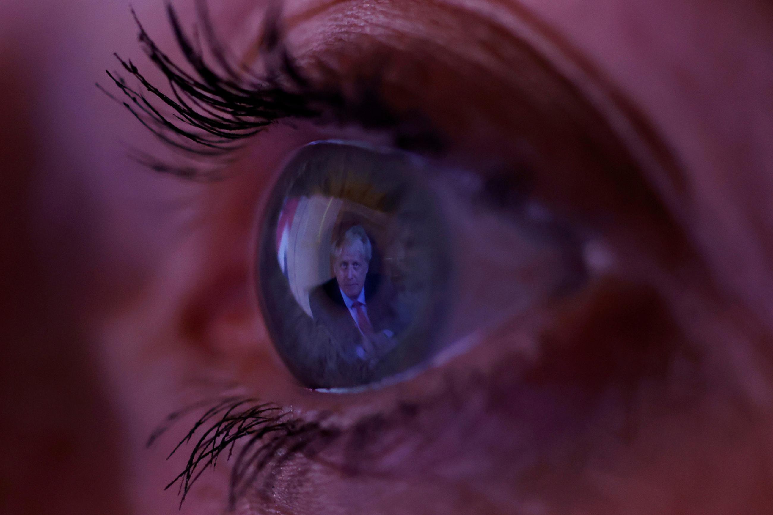 Britain's Prime Minister Boris Johnson is reflected in a woman's eye as she watches his address to the nation following the outbreak of coronavirus in Manchester, England, on September 22, 2020. The photo shows a macro lens image of an eye with the image of the PM reflected in it. REUTERS/Phil Noble