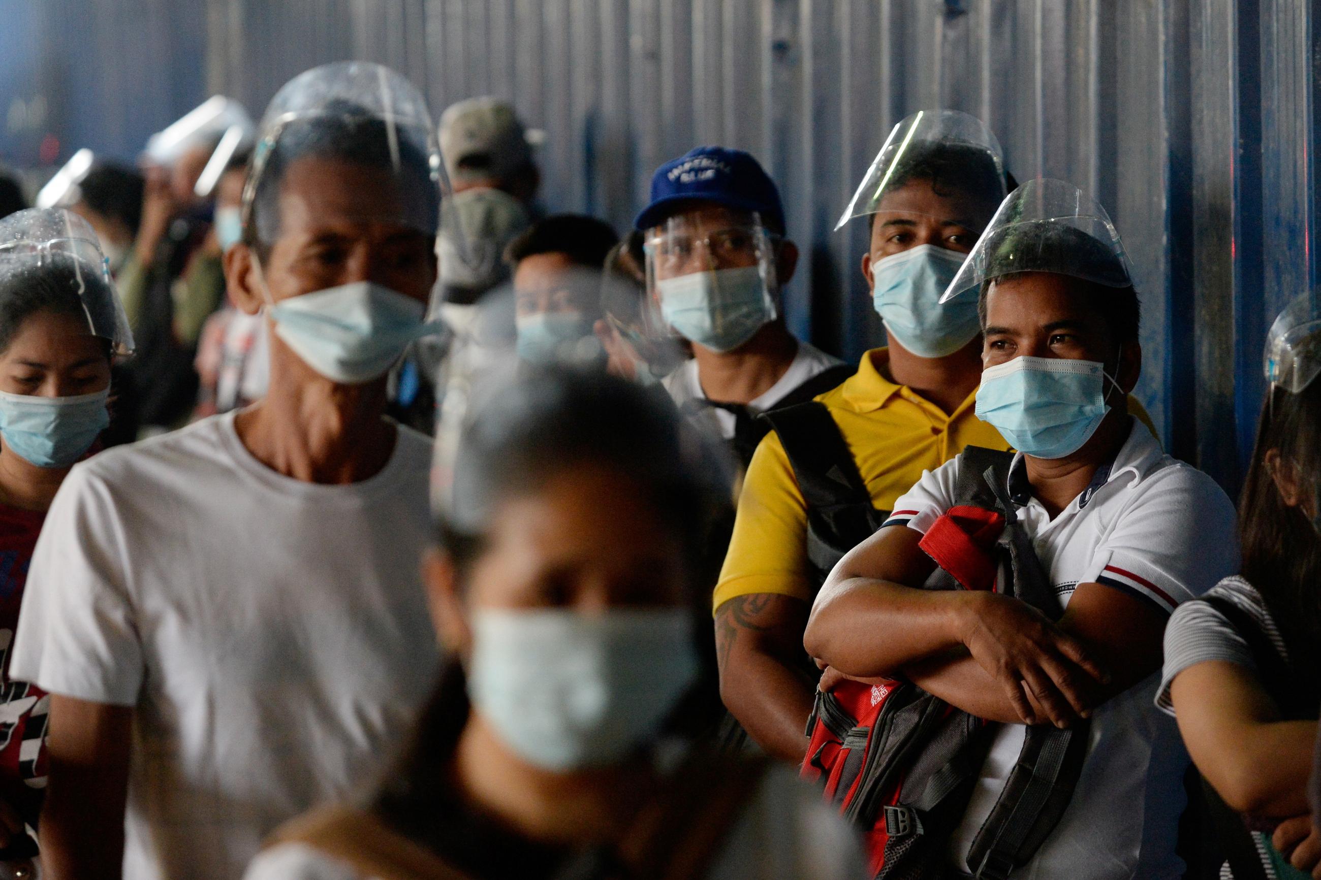 People wearing face masks as protection against the coronavirus disease (COVID-19) queue outside a government office, in Caloocan City, Metro Manila, Philippines, February 1, 2021. 