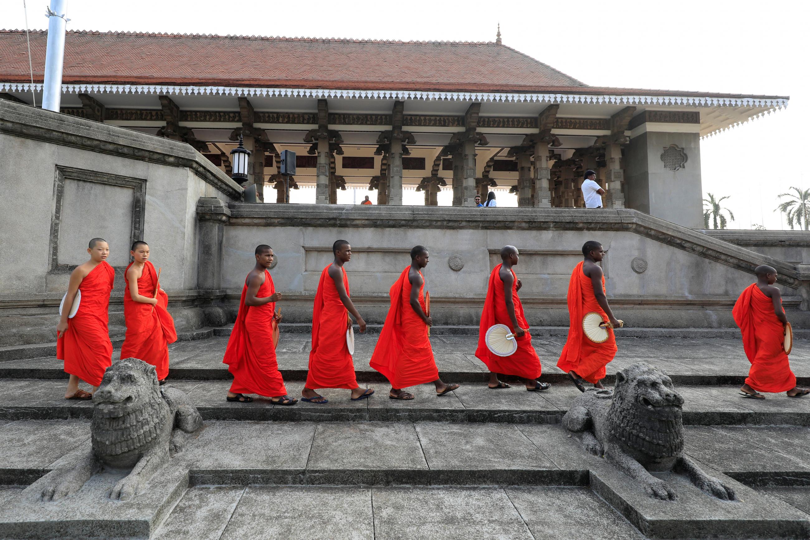 Monks dressed in red cross a temple 