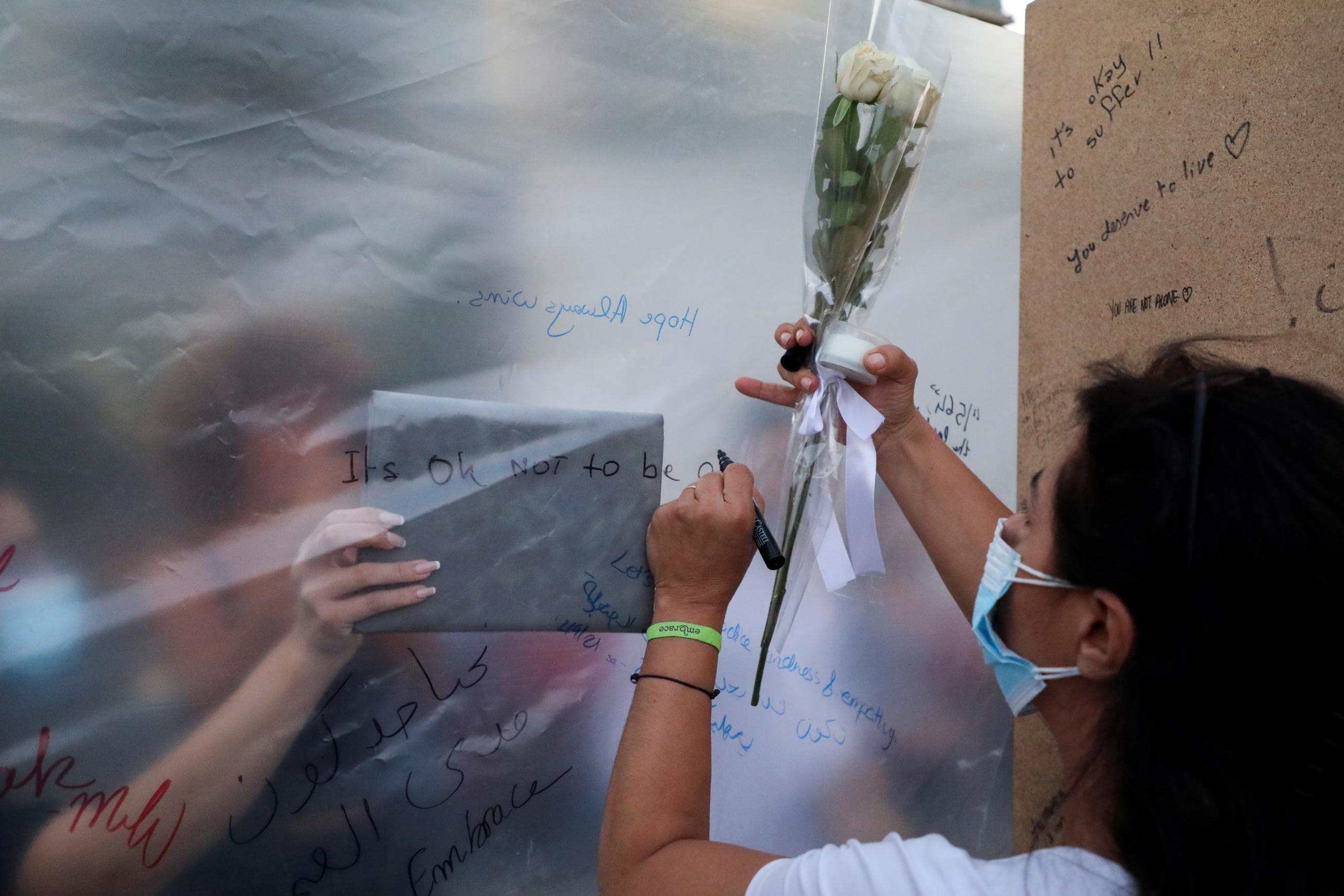 People write notes at the end point of a silent walk organized by Lebanese non-profit organization Embrace, marking World Suicide Prevention Day