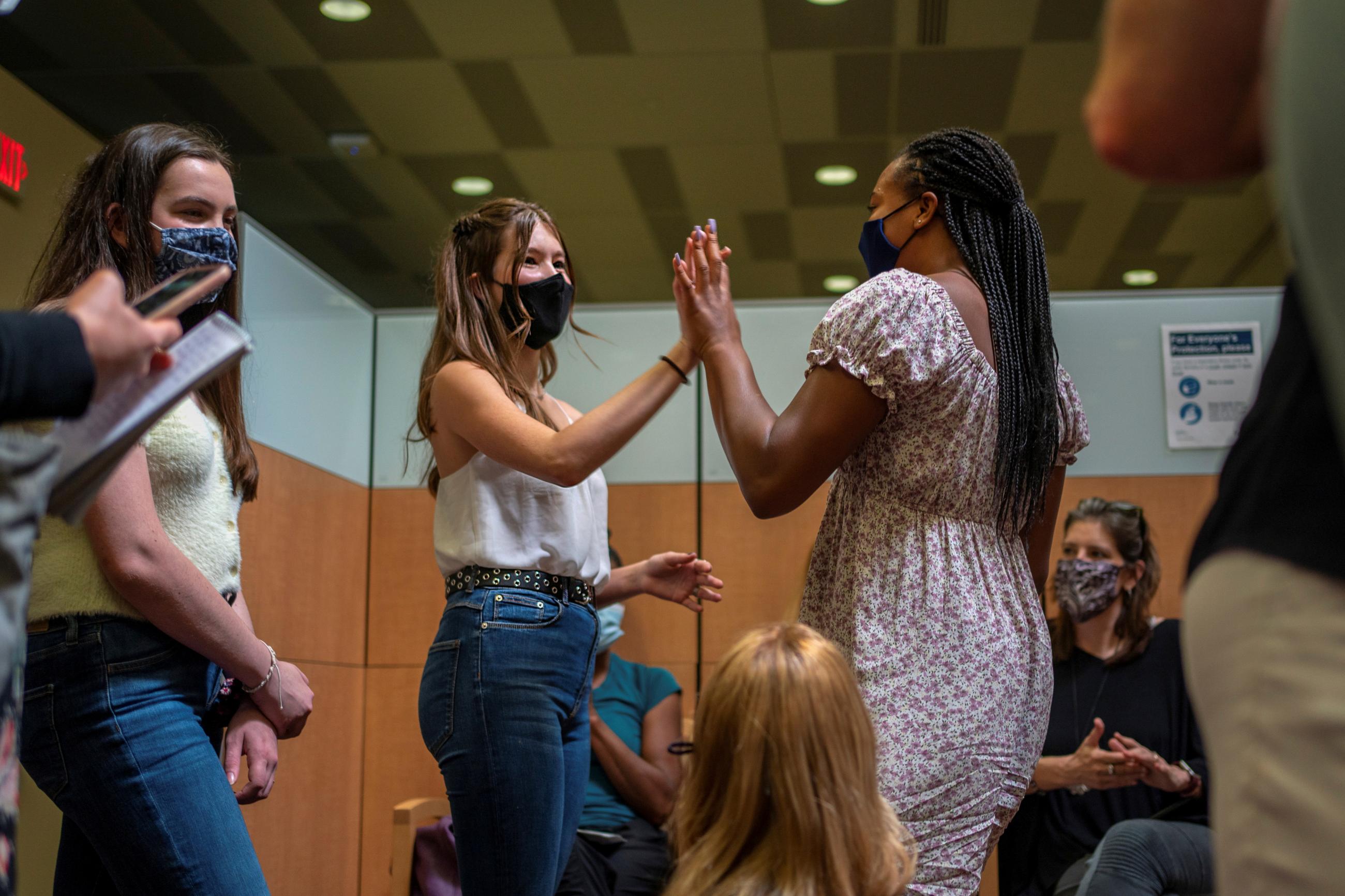 Ava Kreutziger, 14, gives Croix Hill, 15, a high five after Croix received her first dose of the COVID-19 vaccine at the Ochsner Center for Primary Care and Wellness, in New Orleans, Louisiana, May 13, 2021. 