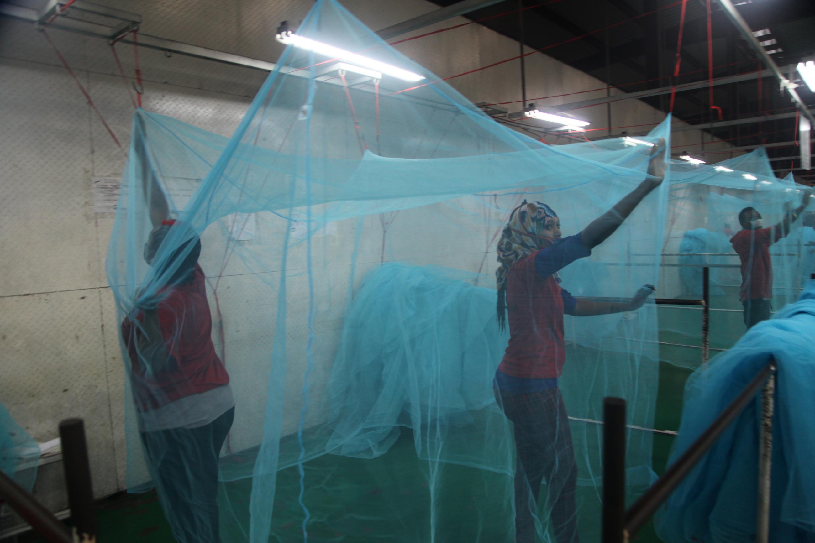 Employees look for holes in mosquito netting at the A to Z Textile Mills factory where insecticide-treated bed nets are produced, in Arusha, Tanzania, on May 10, 2016.