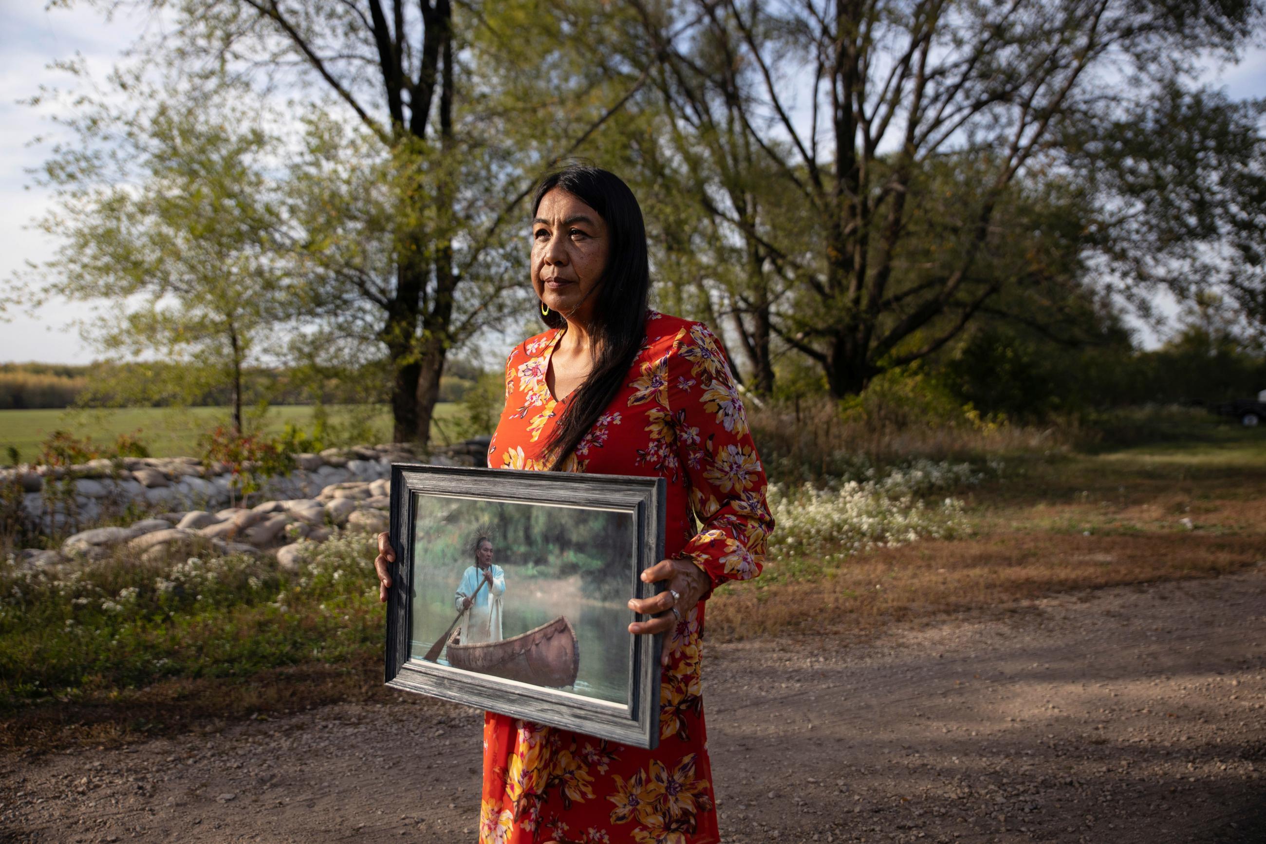 A woman holds a portrait of her late husband after he passed away due to a diabetes-related heart attack, in Red Wing, Minnesota, on September 29, 2021.
