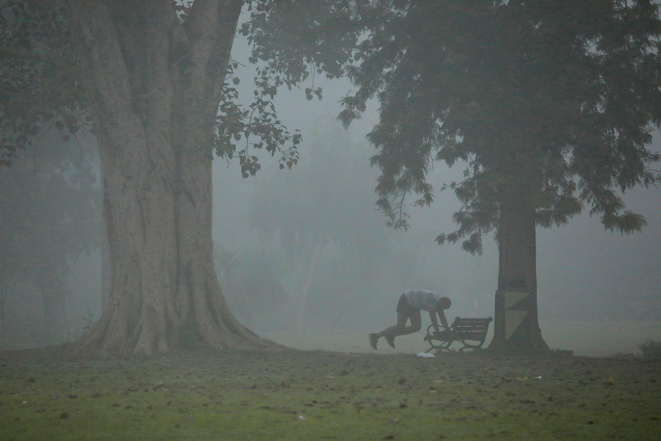 A man exercises in a park on a smoggy morning in New Delhi, India, on November 9, 2017.