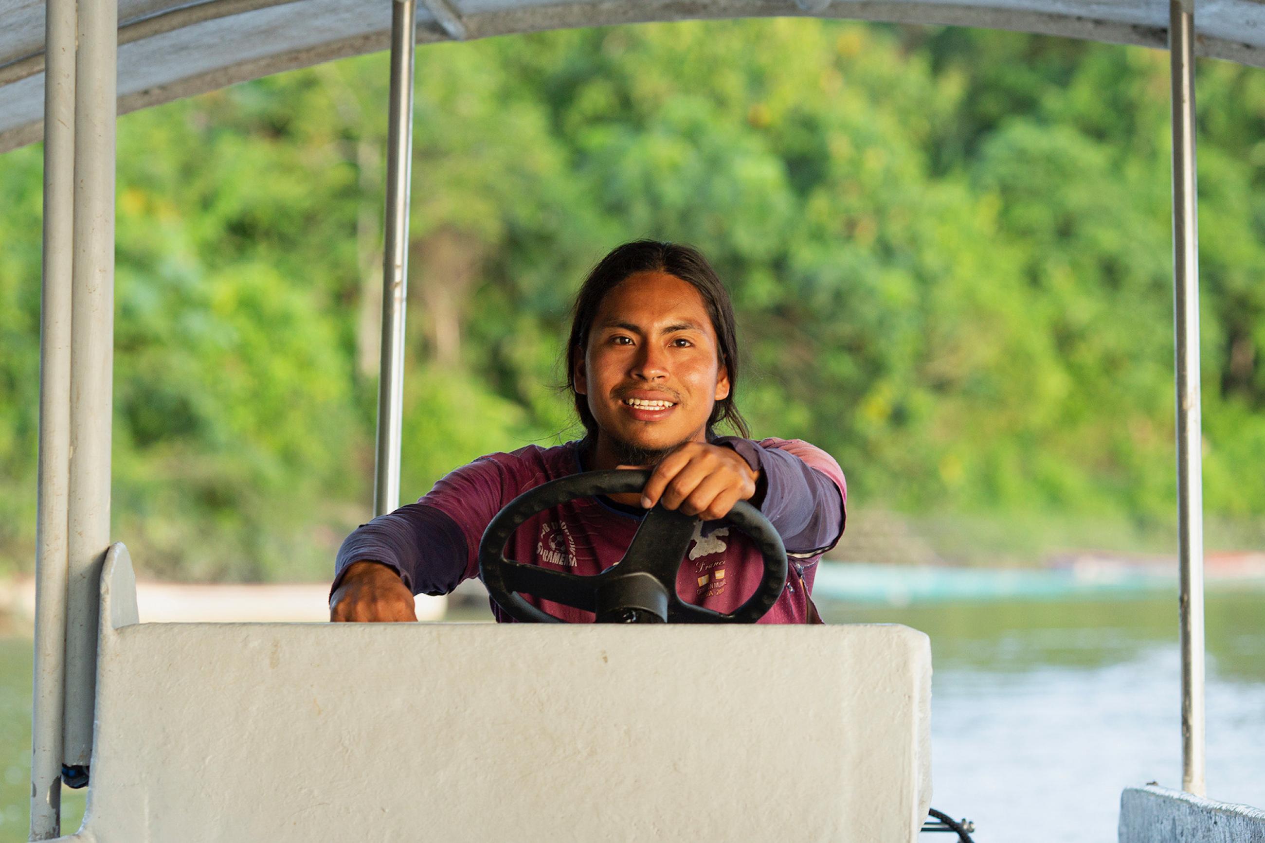 Luciano Peas, a member of the Achuar Indigenous community in Ecuador, captains a solar-powered boat.