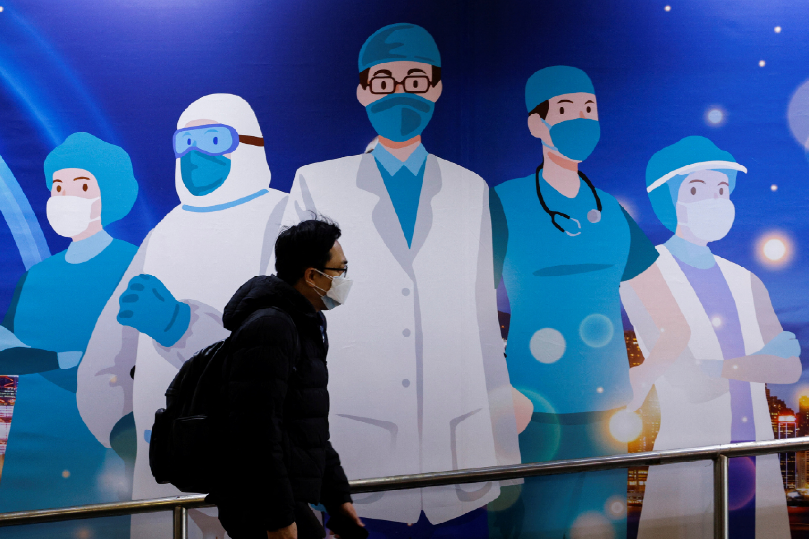 A man walks past street art supporting medical professionals during the COVID-19 outbreak in Hong Kong on February 24, 2022. Photo by REUTERS/Tyrone Siu