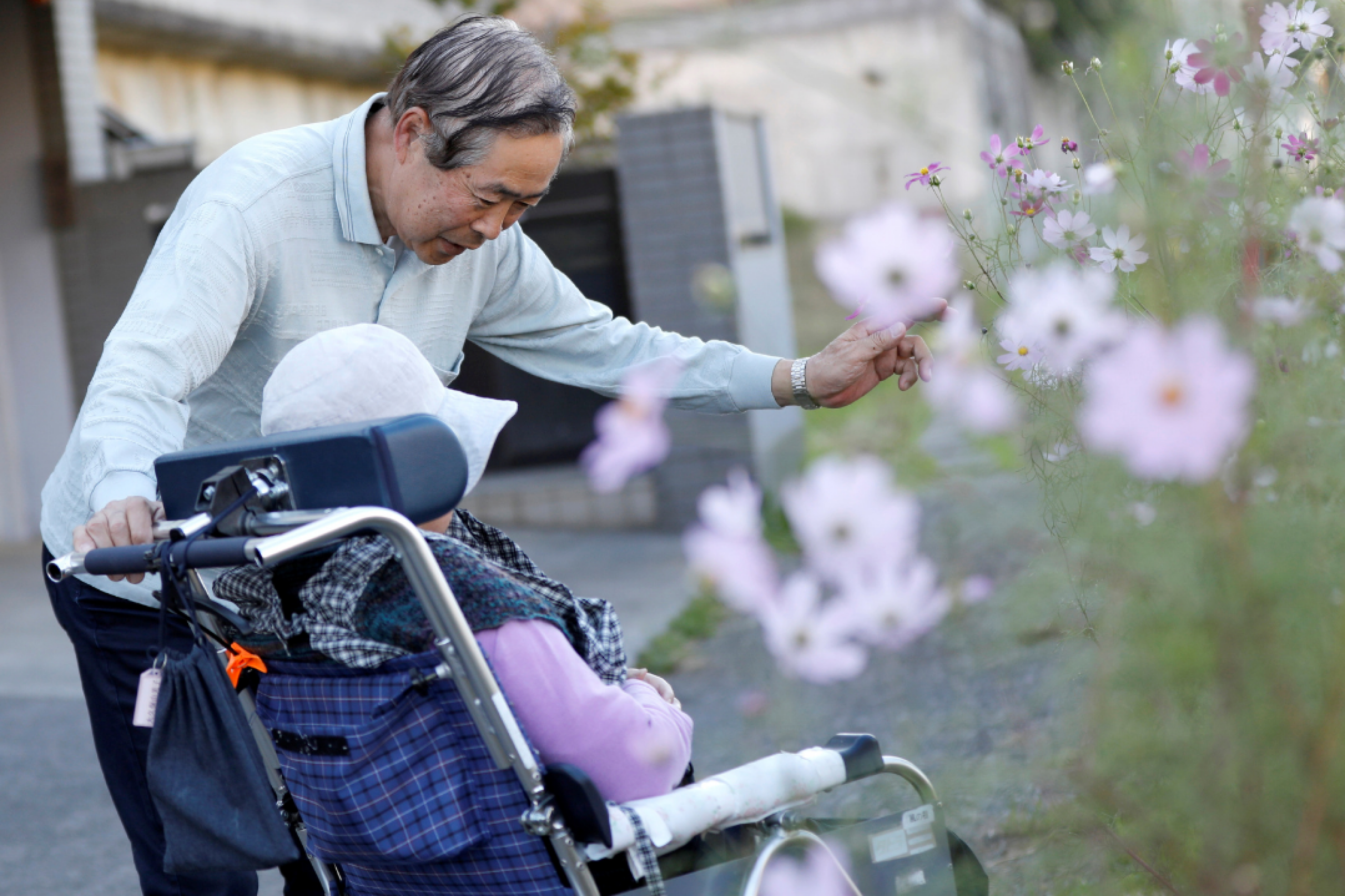 Eiichi Okubo, 71, speaks to his wife Yumiko, 68, who has been suffering from dementia, near her care house in Tokyo, Japan, on October 29, 2018.