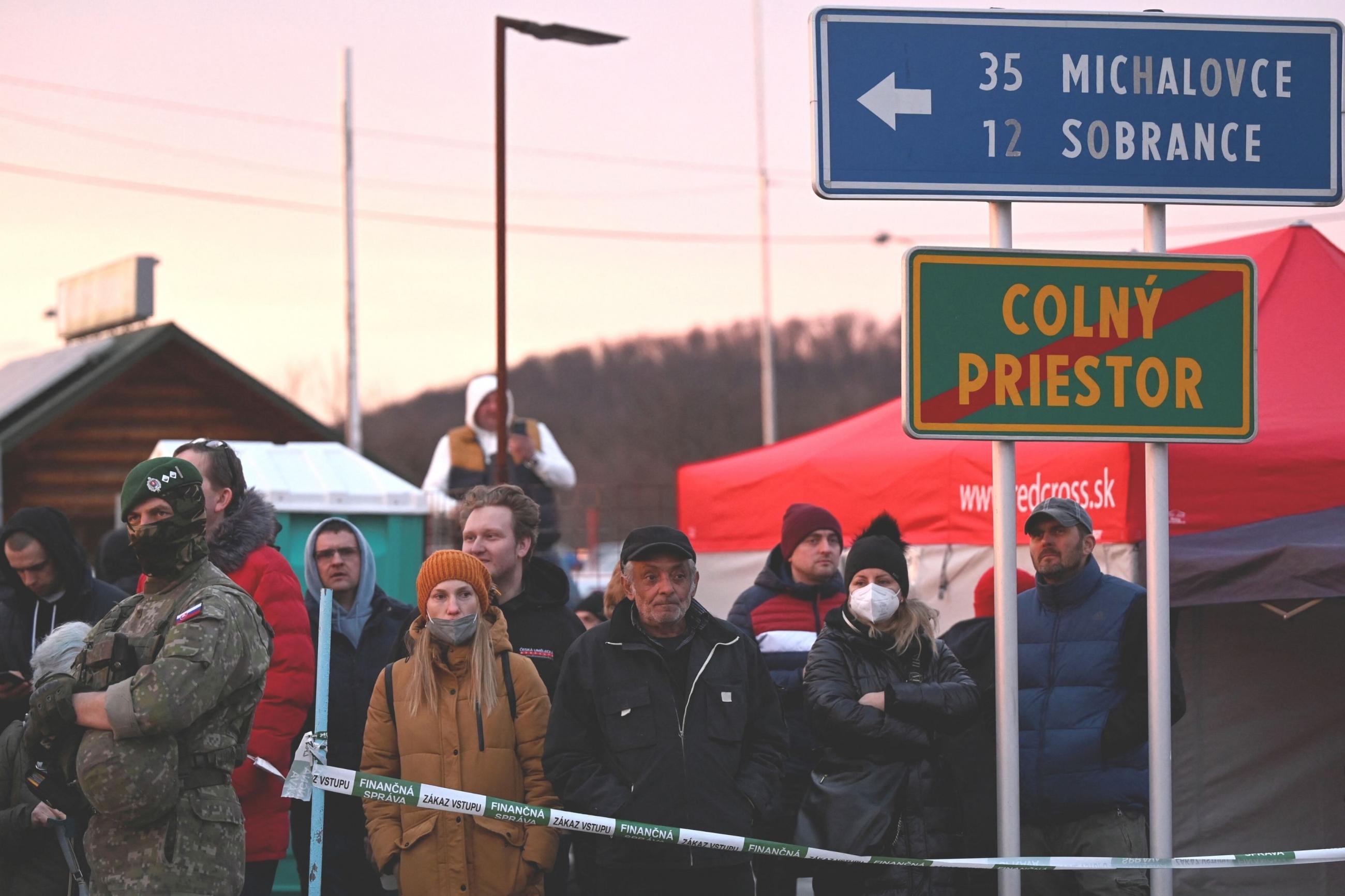 People wait at the Ukrainian border in Vysne Nemecke, Slovakia, after Russia launched a massive military operation against Ukraine