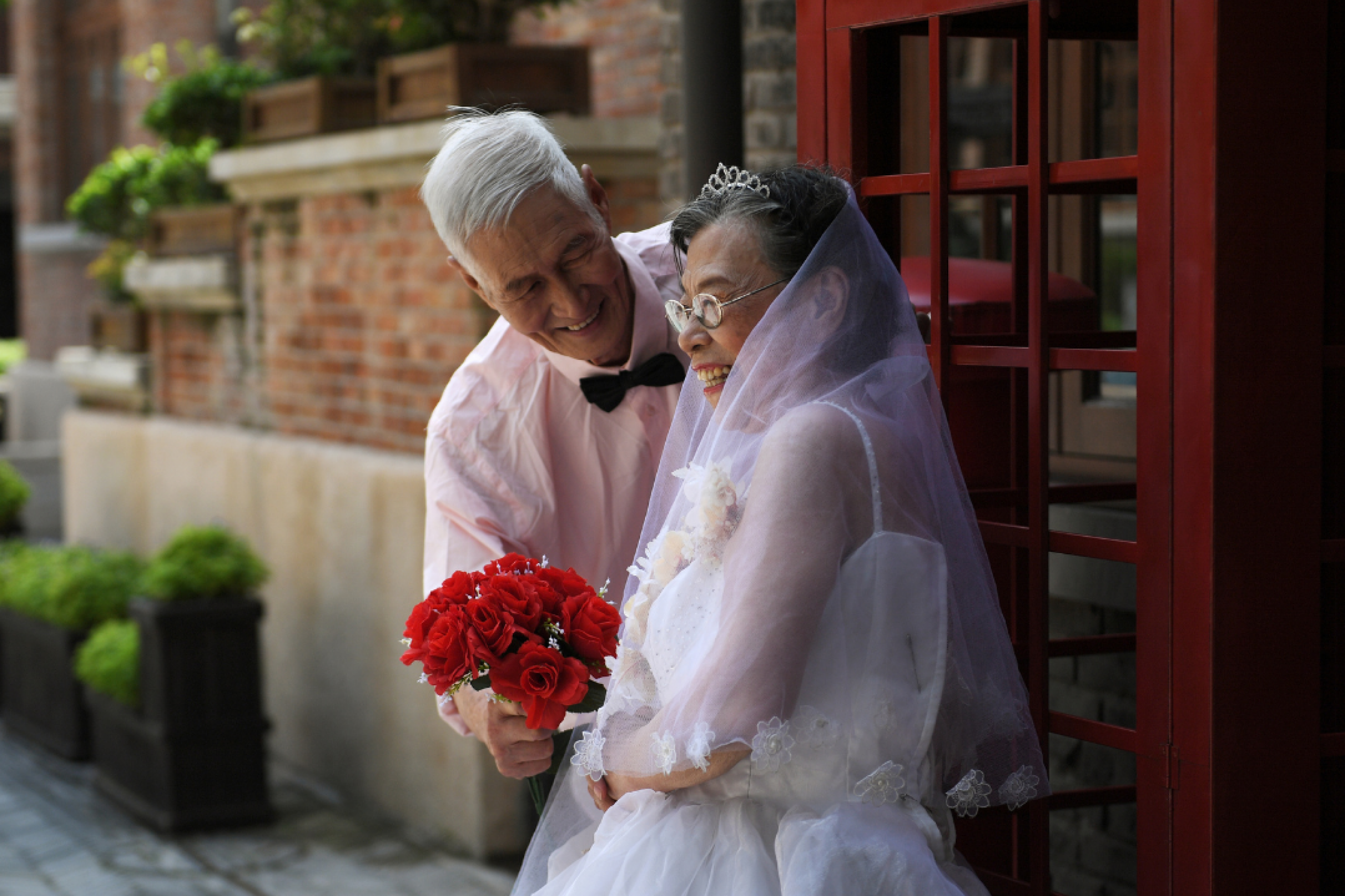 Chen Guozhi, 85, and his wife Chen Suzhen, 82, pose during a photo shoot to recreate wedding photos for elderly couples, who have been married for more than 50 years, Tianjin, China, August 16, 2018