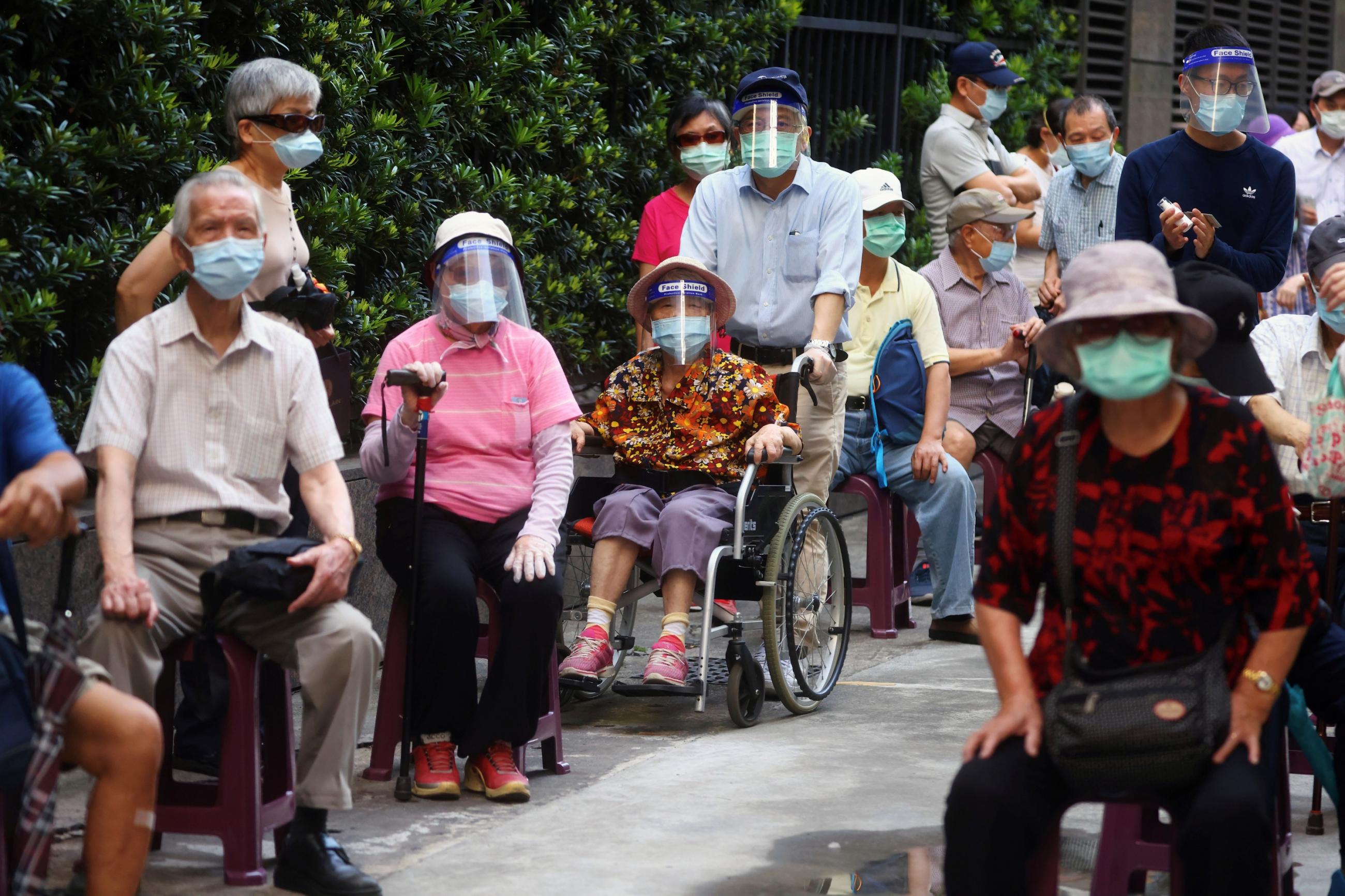 Older people in wheelchairs and blue masks line up to receive the vaccine against the COVID-19 during a vaccination session for elderly people over 85 years old, at a church in Taipei, Taiwan on June 15, 2021.