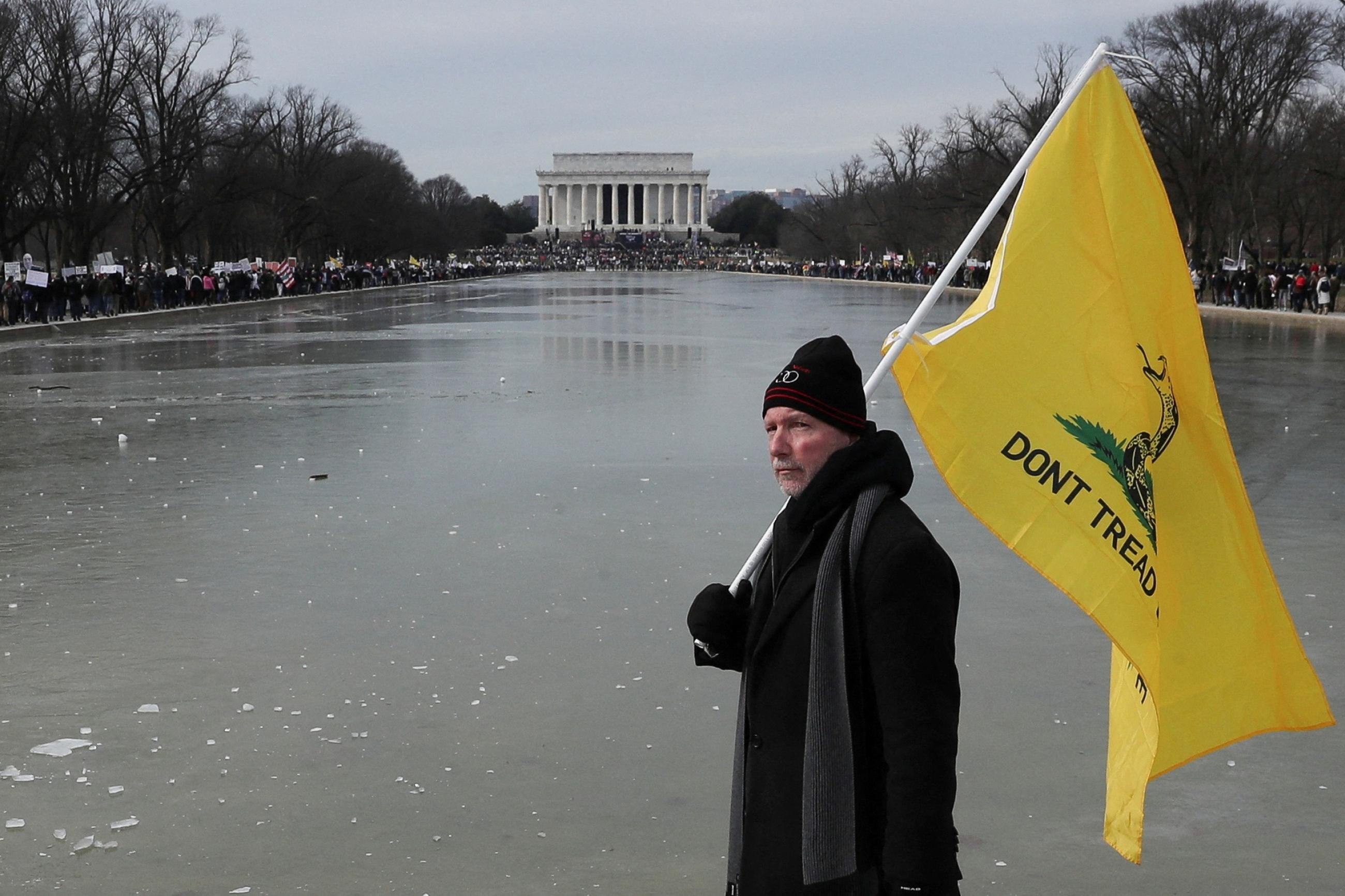 A man holds a flag during a march in opposition to coronavirus disease (COVID-19) mandates on the National Mall in Washington, D.C