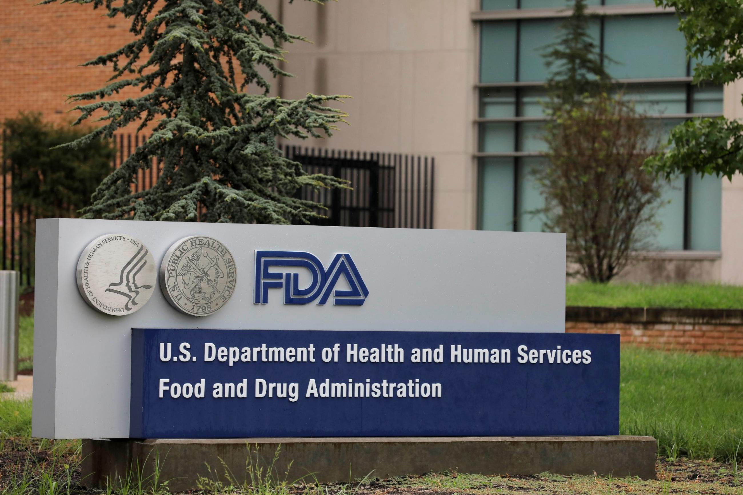 A blue and silver sign that reads "FDA: U.S. Department of Health and Human Services Food and Drug Administration" is seen in the lawn outside the FDA building in Maryland
