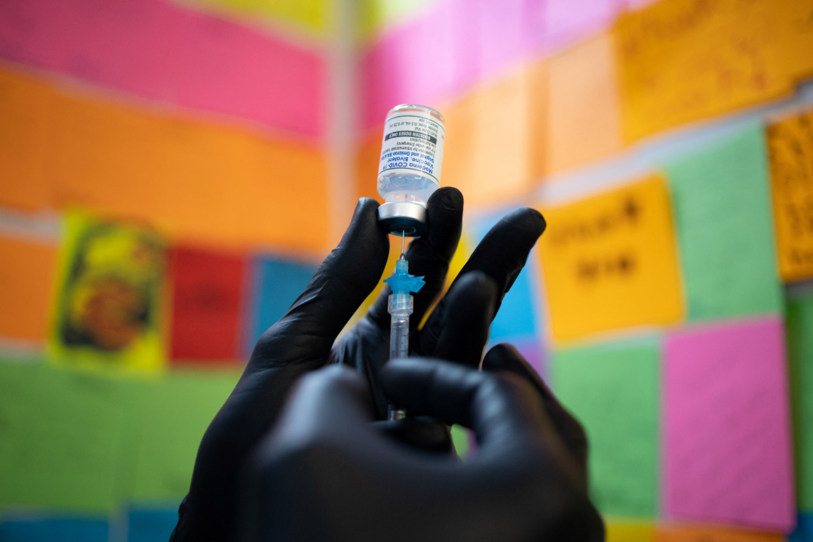 A close-up photo of a hand in a black medical glove shows Dr. Mayank Amin preparing a Moderna COVID booster vaccine targeting BA.4 and BA.5 omicron subvariants, at Skippack Pharmacy in Schwenksville, Pennsylvania, September 8, 2022. 