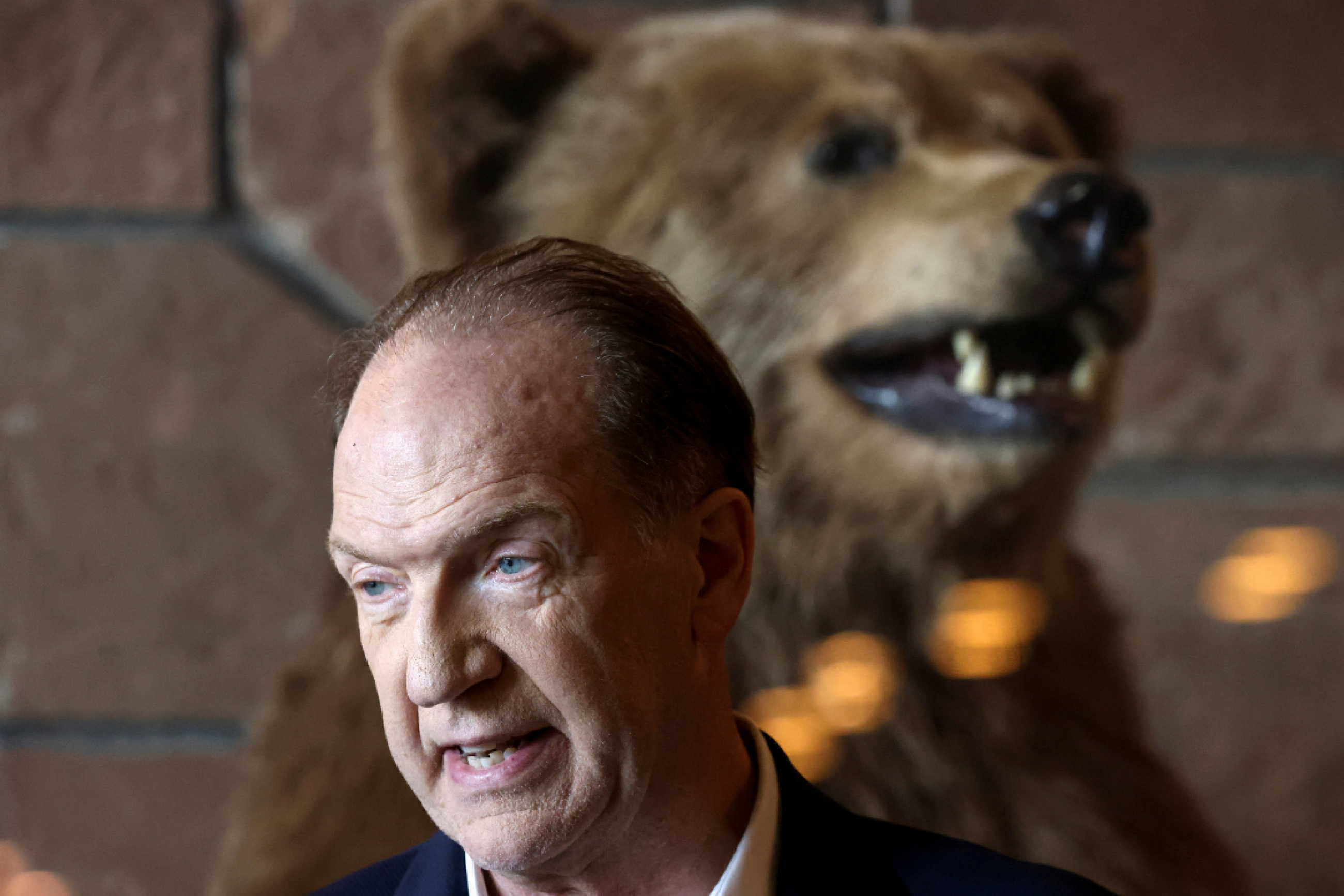 David Malpass, president of the World Bank Group, and a stuffed grizzly bear at Teton National Park, where financial leaders gathered for the Jackson Hole Economic Symposium, near Jackson, Wyoming, on August 26, 2022. 
