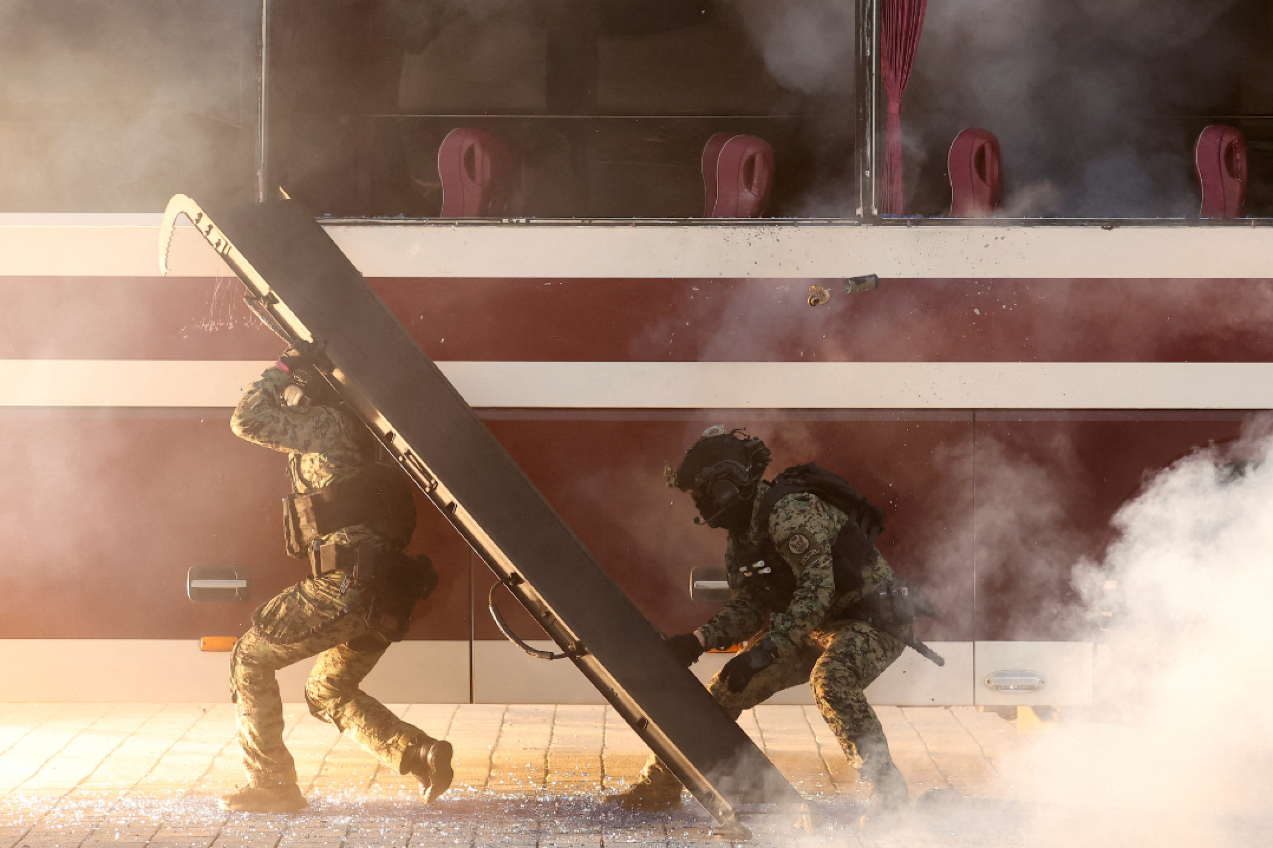 A golden-white smoke wafts in the air around South Korean anti-terrorist soldiers take part in an anti-terror drill to prepare for chemical and drone attacks, at Korea International Exhibition Center, in Goyang, South Korea, on October 27, 2022. 