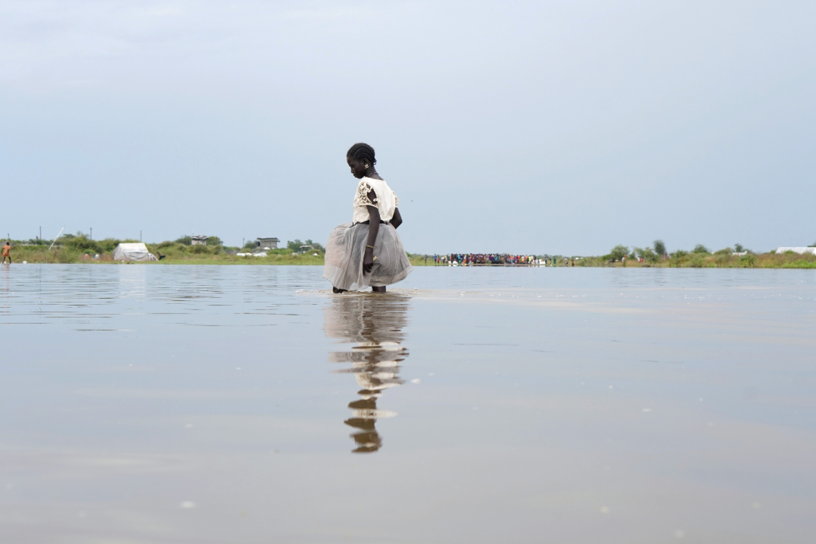 A girl dressed in white walks knee-deep in water after heavy rains and floods in the town of Pibor, Boma state, South Sudan, on November 6, 2019.