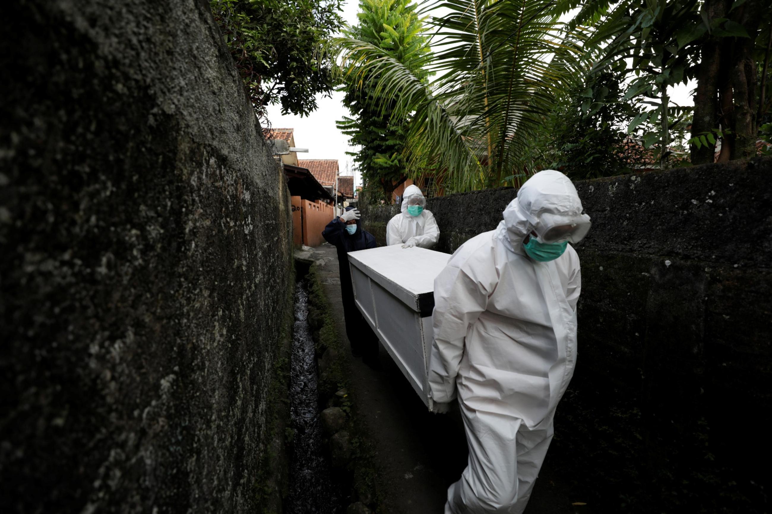 Volunteer undertakers help carry the coffin of 64-year-old Yoyoh Sa'diah who passed away due to complications related to COVID-19, at home in Bogor, West Java province, Indonesia, on July 8, 2021.