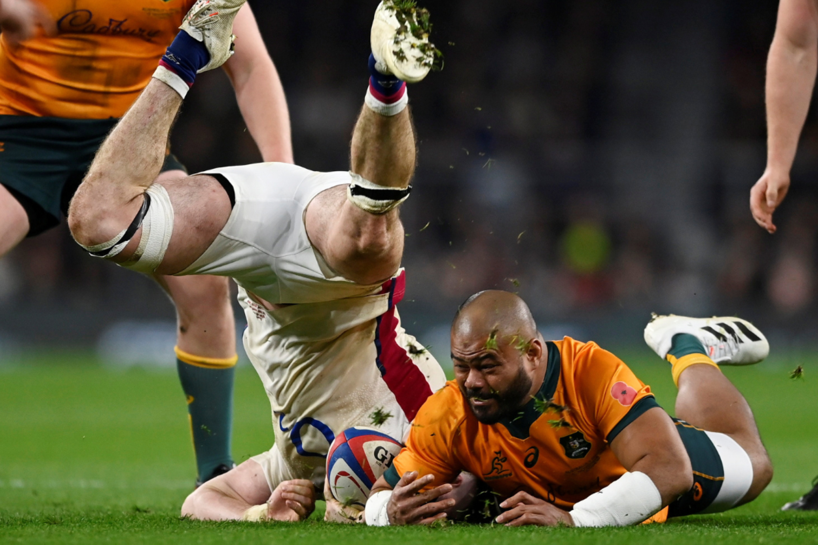 England's Tom Curry tumbles head down over Australia's Tolu Latu on the rugby pitch at Twickenham Stadium, in London, Uk, on November 13, 2021.