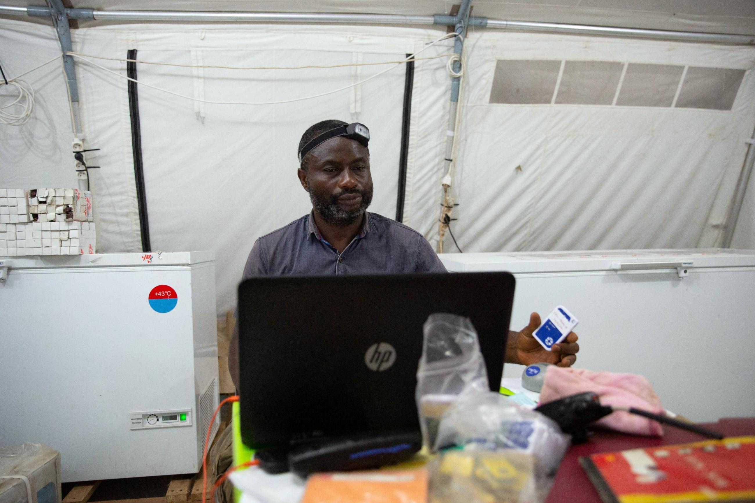 Benjamin Makele, logistician responsible for the cold chain with Doctors Without Borders (MSF), prepares to plug a vaccine temperature log into his computer in Boso-Manzi in Mongala province in the Democratic Republic of Congo February 27, 2020.