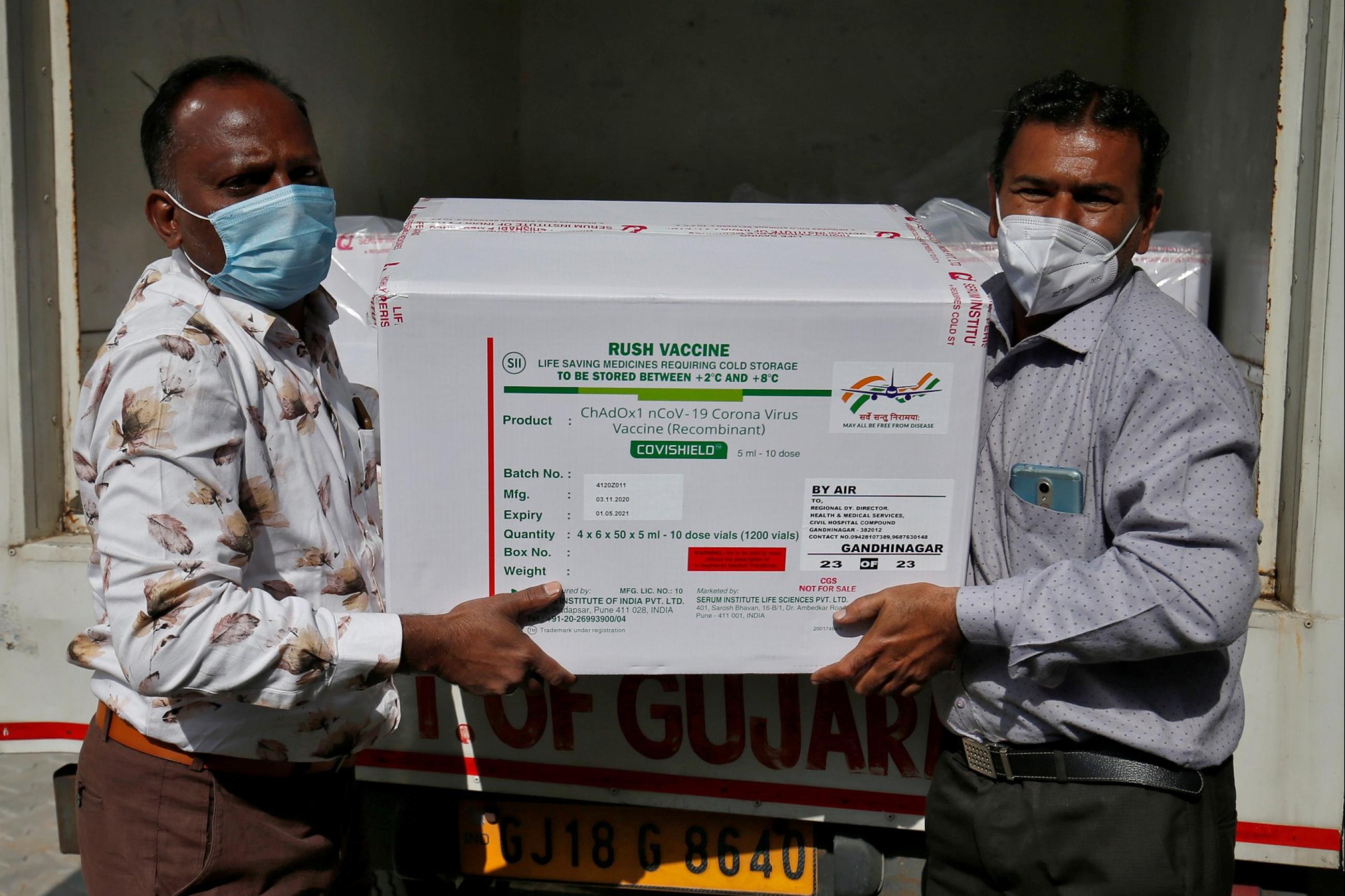workers unload a box of covid vaccines