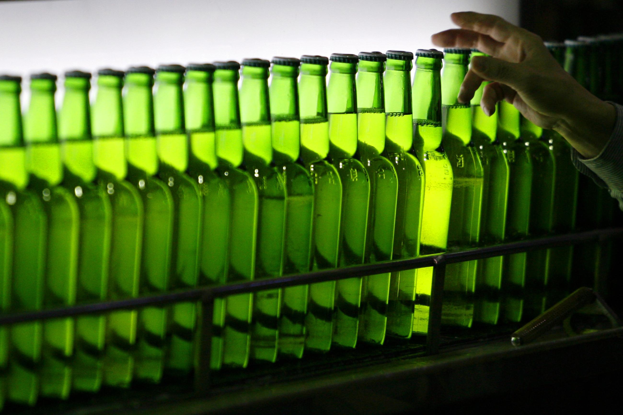 A man picks a green bottle at an assembly line inside the Taiwan Beer factory in Jhunan, Miaoli County, Taiwan, February 13, 2008.