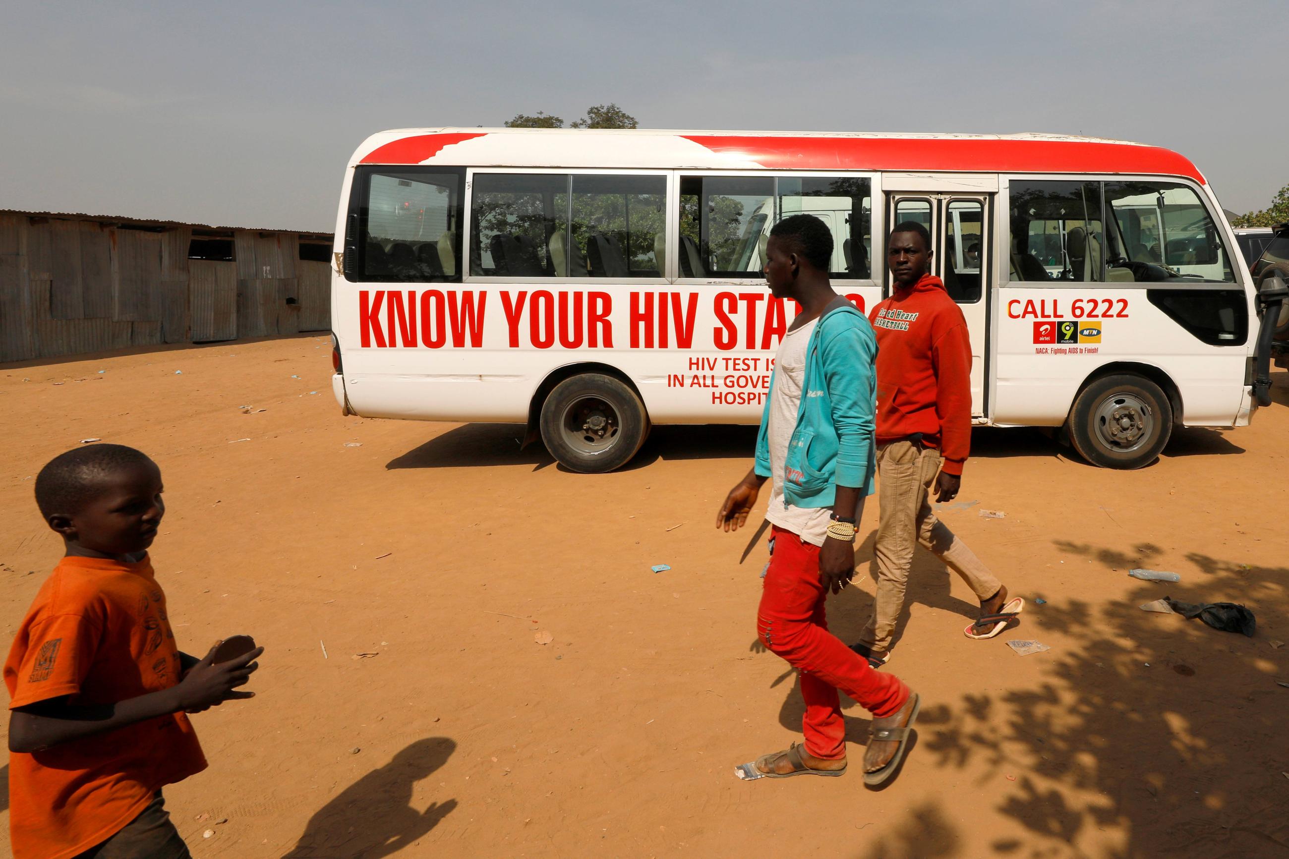 People walk past a bus during an HIV/AIDS awareness campaign on the occasion of World AIDS Day in Abuja, Nigeria, December 1, 2018.