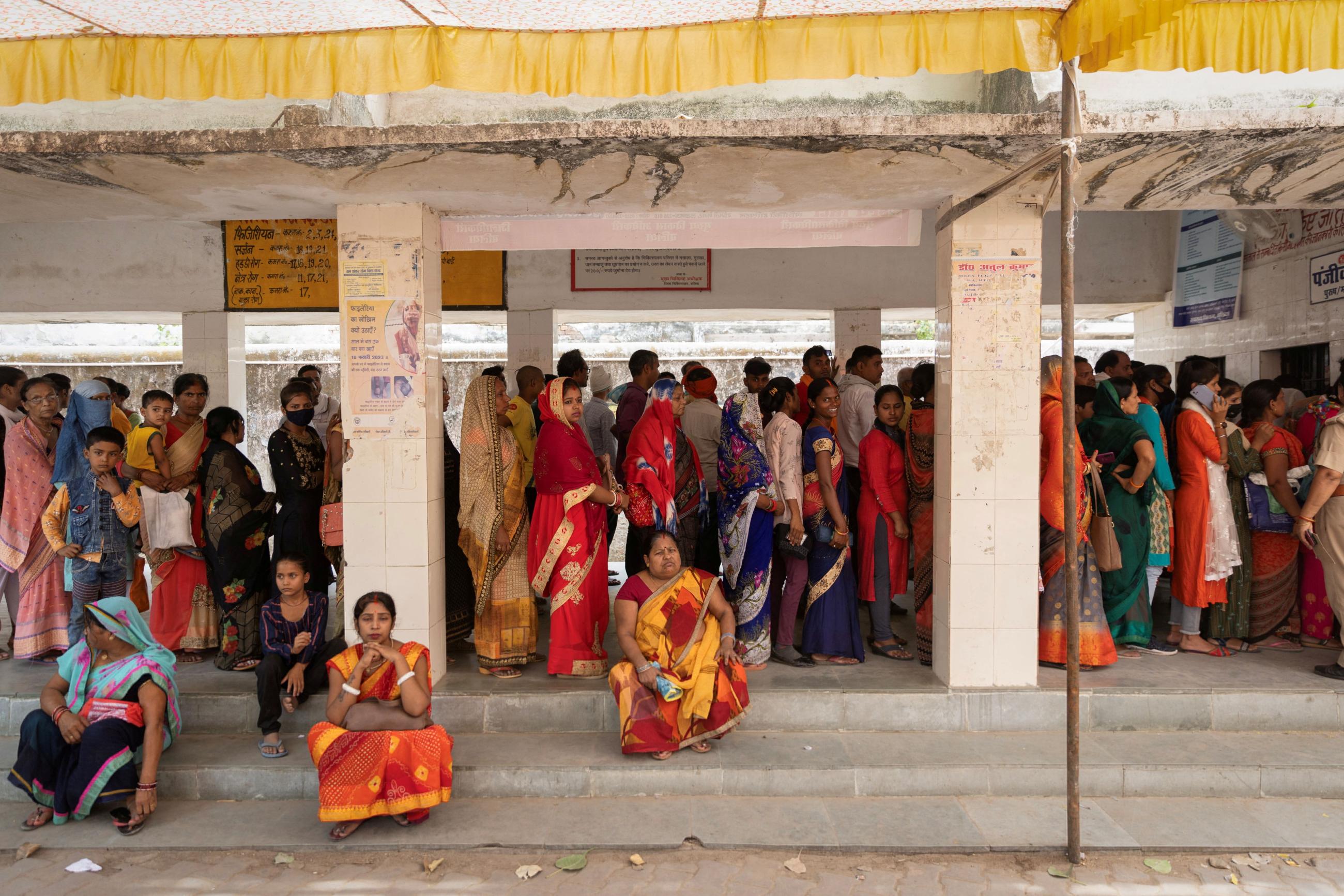 People stand in queues at a registration center at a hospital on a hot summer day in Ballia District in the northern state of Uttar Pradesh, India, June 21, 2023.