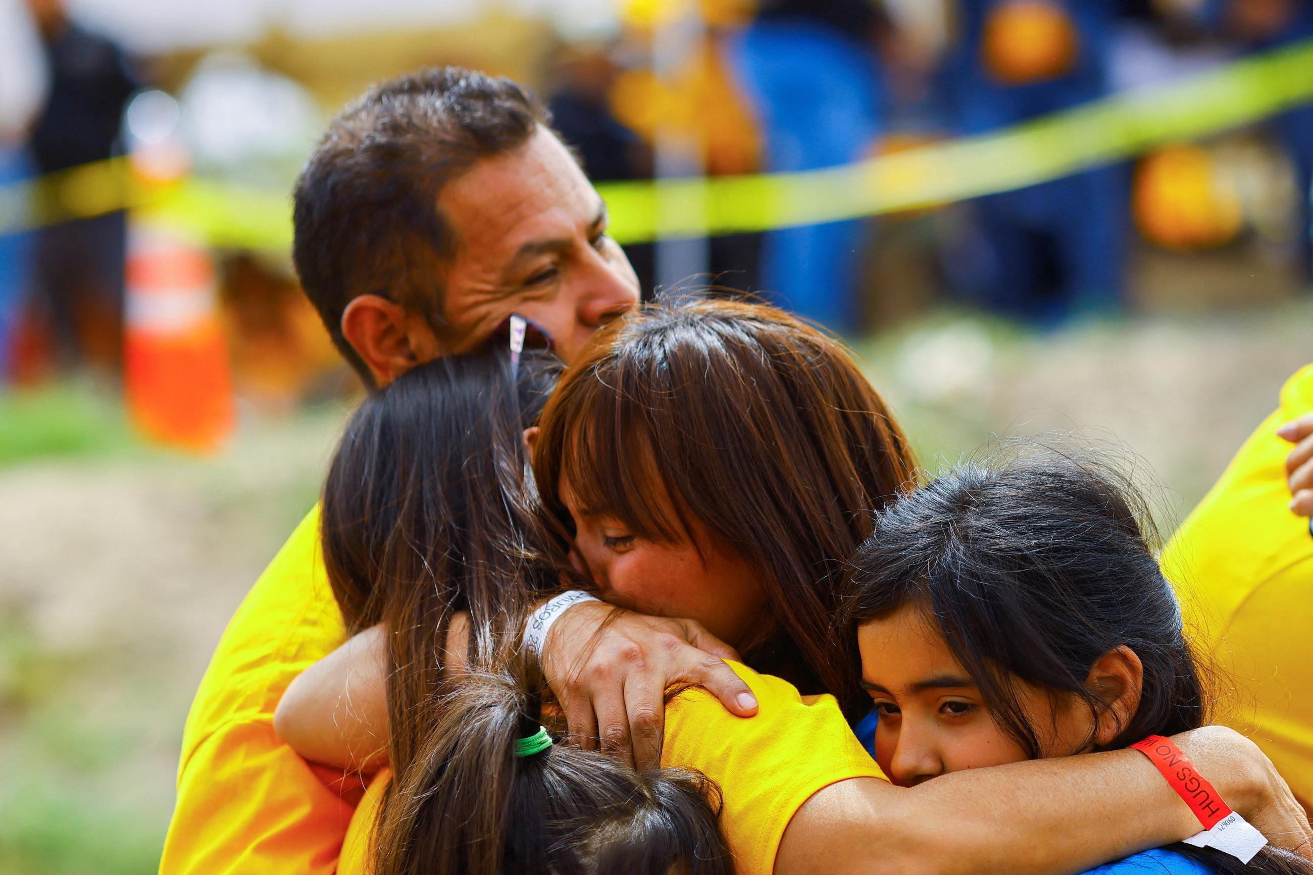 Families hug each other as they participate in a reunification meeting for relatives separated by deportation and immigration.