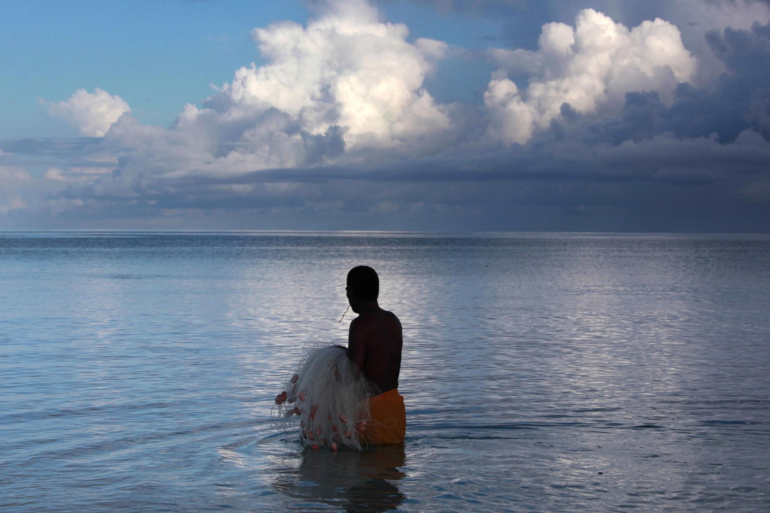 Kaibakia Pinata prepares to cast his net as he wades through water just off Bikeman Islet.
