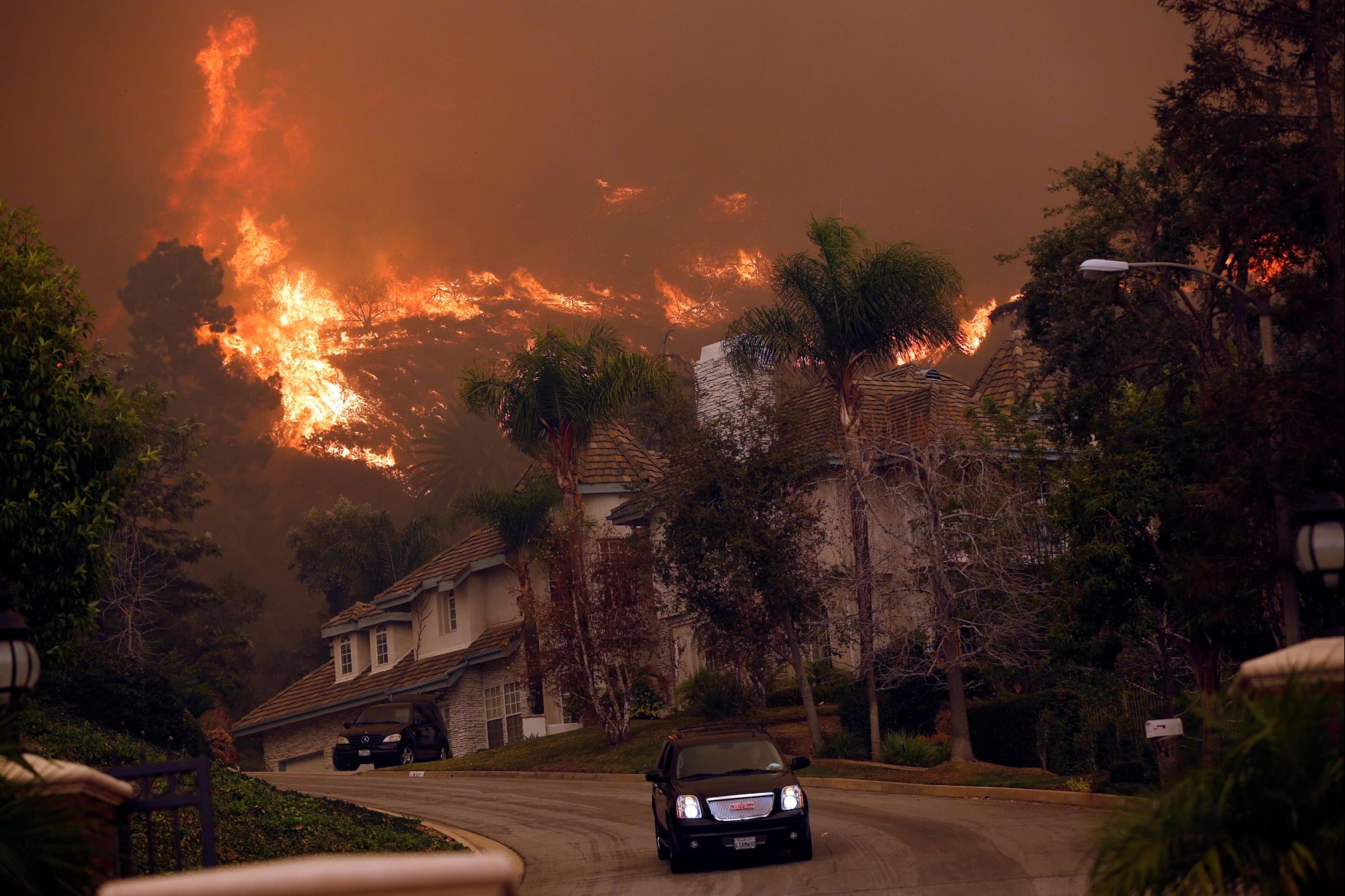 A car drives away from the Colby Fire in hills above Glendora, California January 16, 2014.