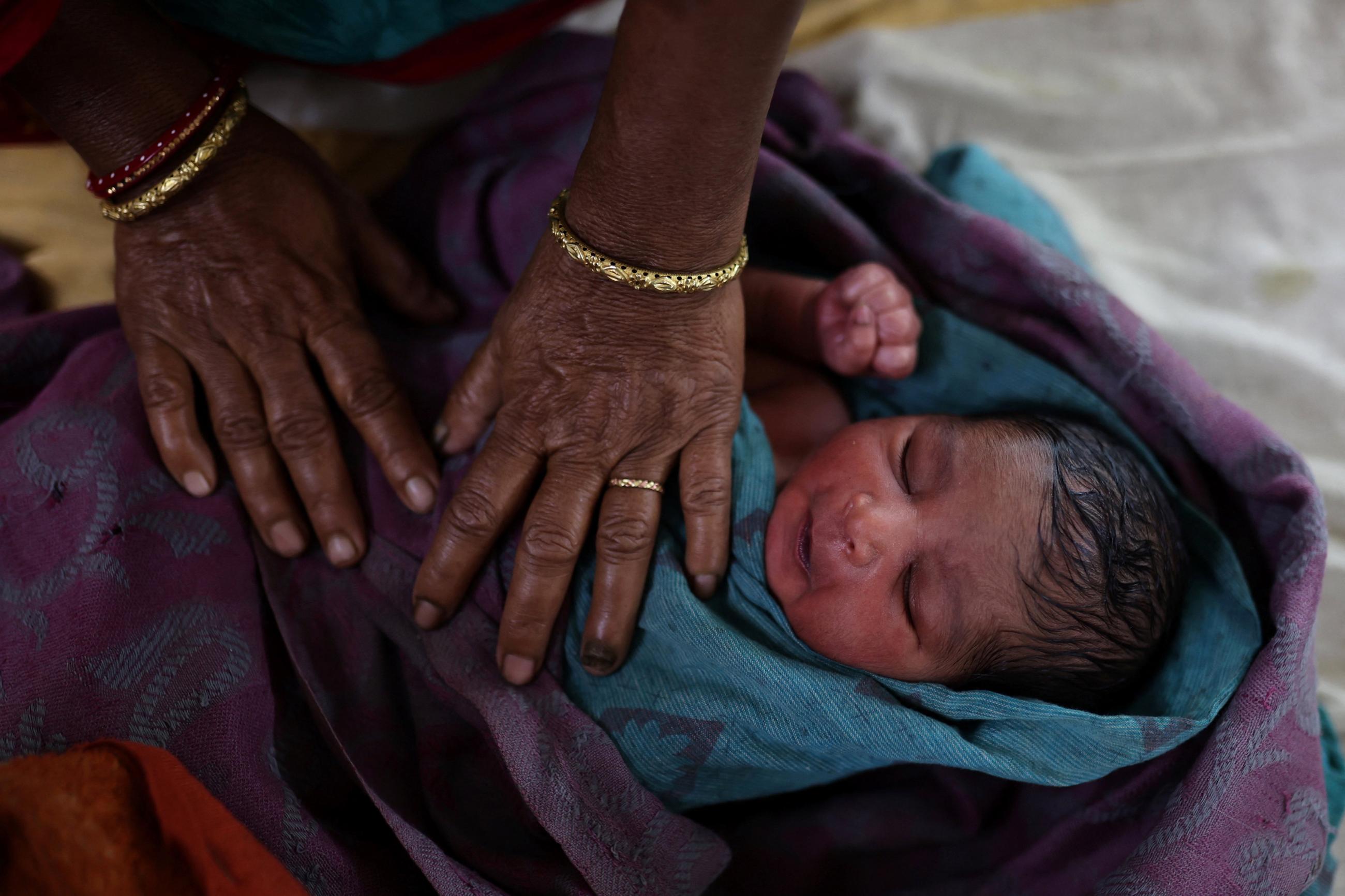 A nurse takes care of a newborn baby after the birth at a hospital in Kishanganj district, Bihar, India, March 20, 2023. India's fertility rate, fell to 2.0 in 2019-2021, but state health officials estimate Kishanganj's fertility rate at 4.8 or 4.9, creating population growth that the state is trying to curb with the distribution of condoms and birth control pills. REUTERS/Anushree Fadnavis