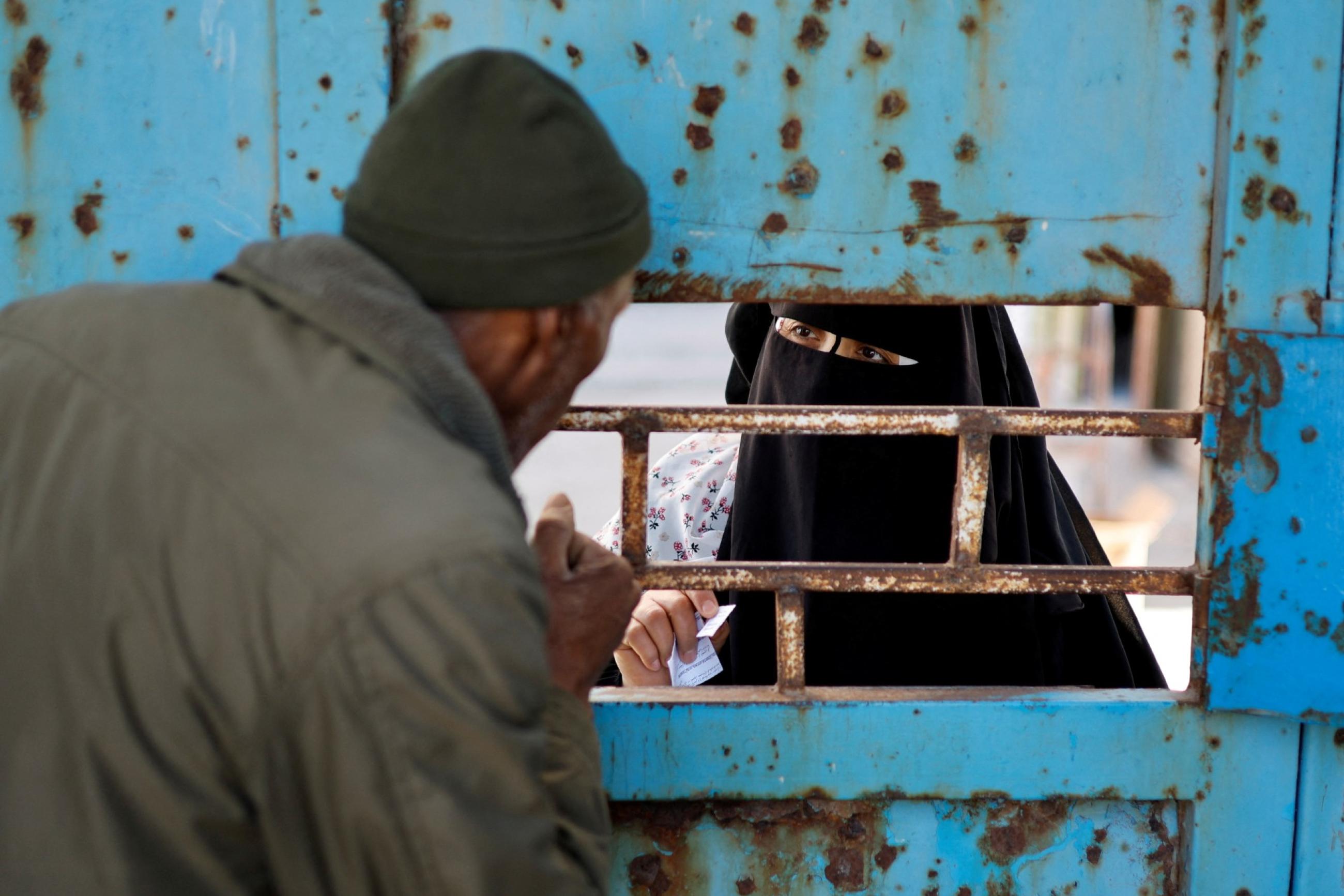 A Palestinian woman waits to receive food supplies at an aid distribution center run by United Nations Relief and Works Agency (UNRWA), at Beach refugee camp in Gaza City March 10, 2022