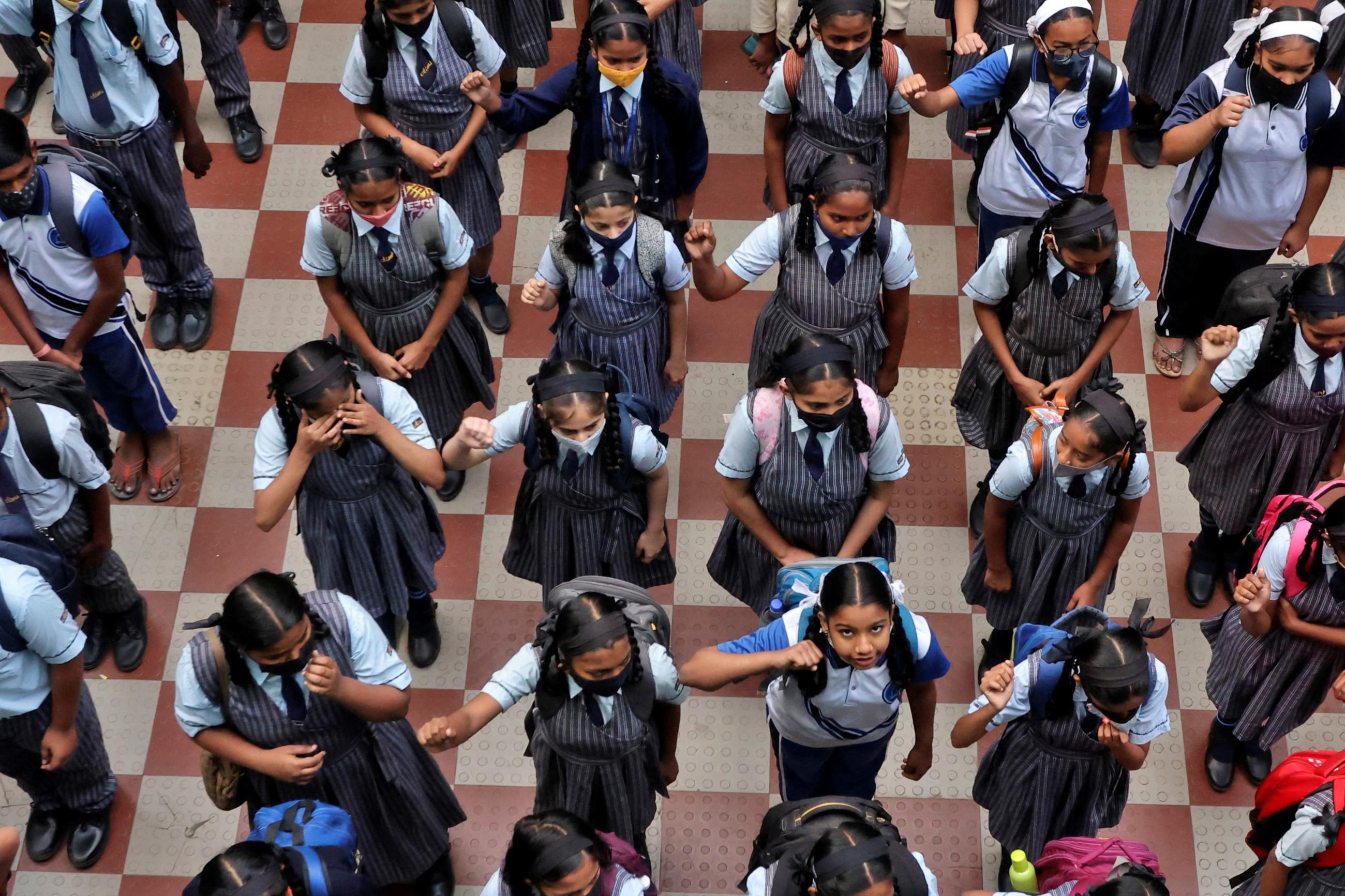 Children assemble for morning prayers after schools reopen with full capacity following their closure due to COVID-19.