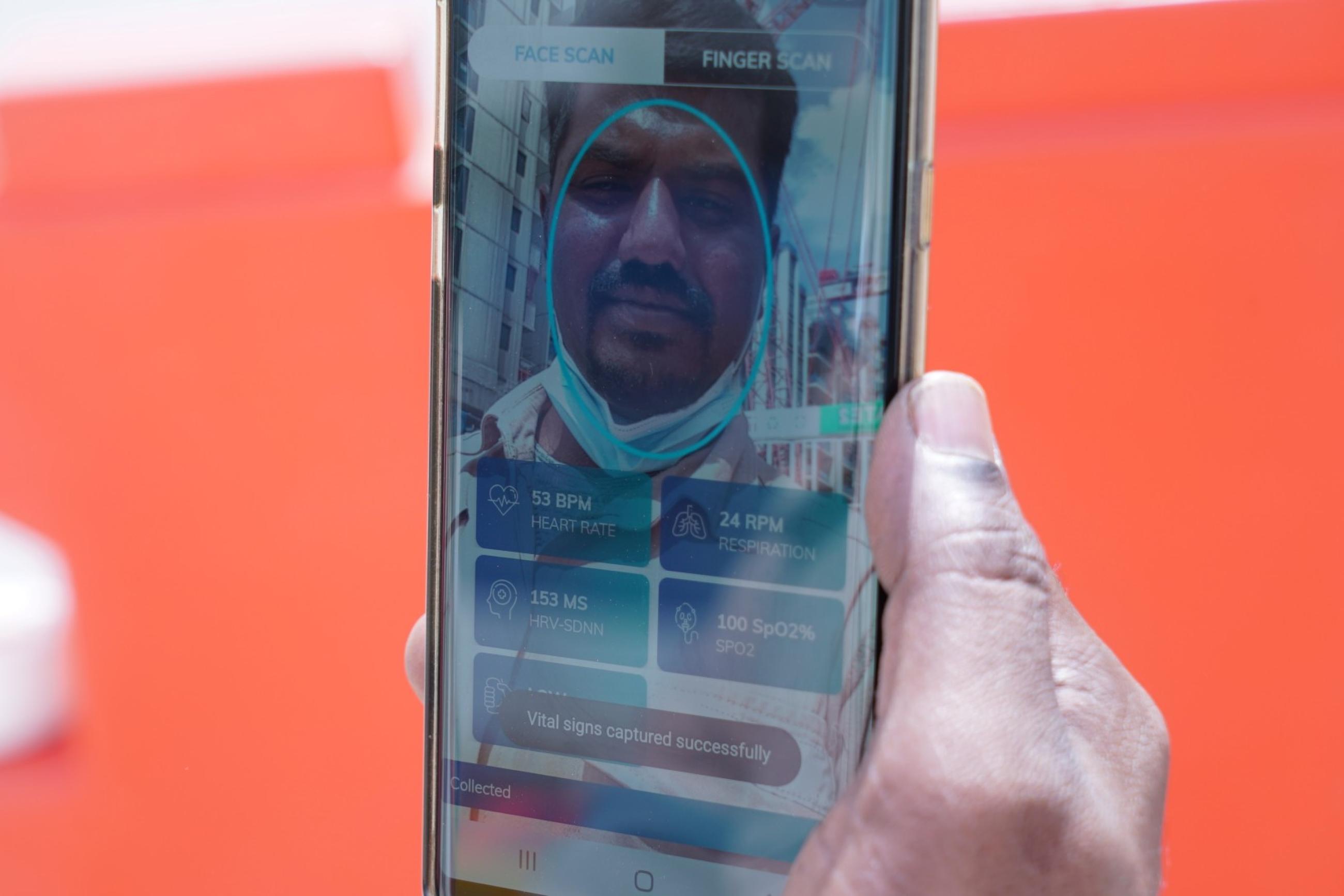 Gunasekar Udayakumar uses the Nervotec app to scan his face and check his vital signs as part of a daily checkup for employees, at a construction site, in central Singapore, on February 19 2021.