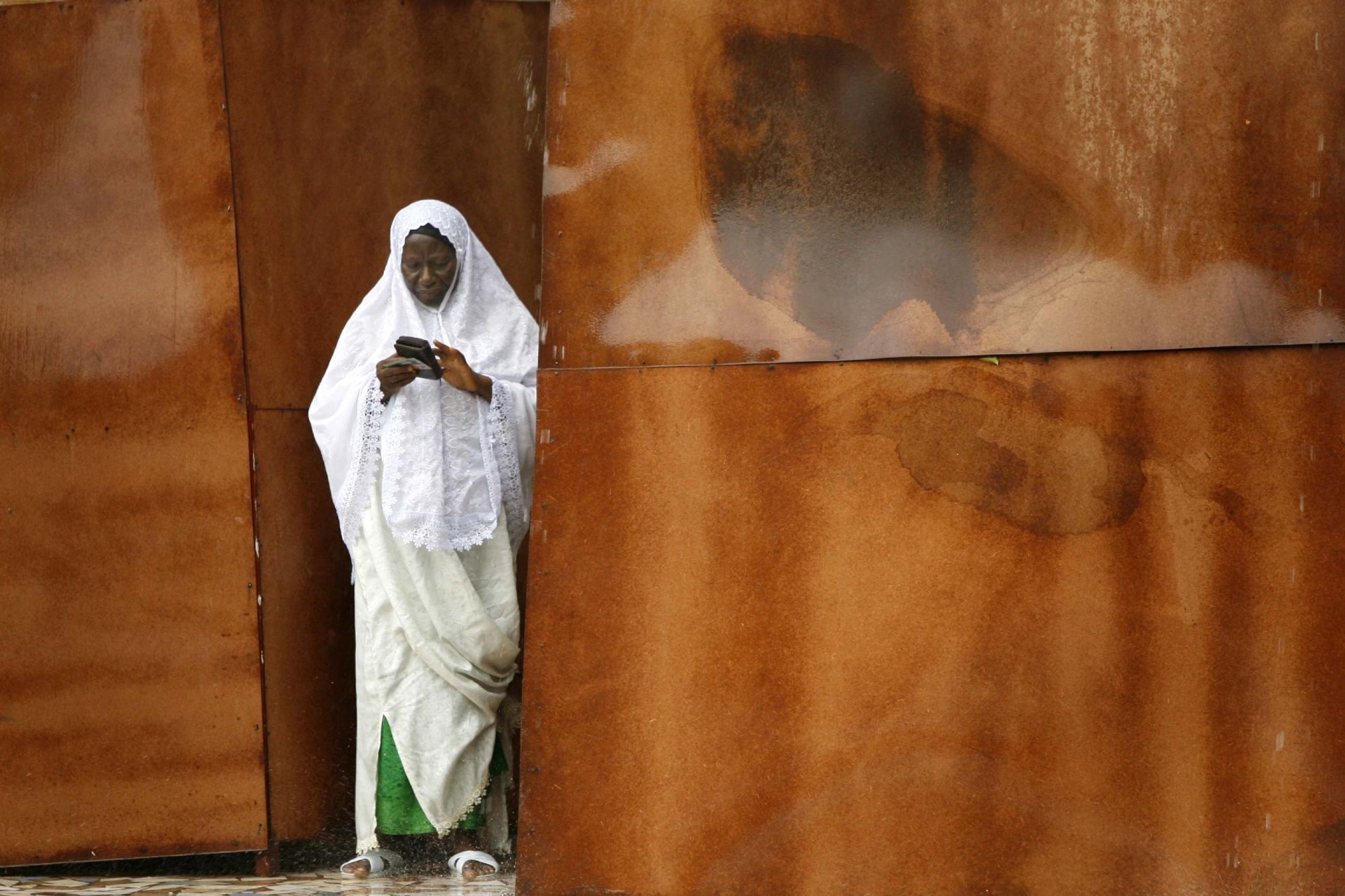 A Gambian woman puts her identity card back into her purse while exiting a polling station, in Serekunda, Gambia, on September 22, 2006.