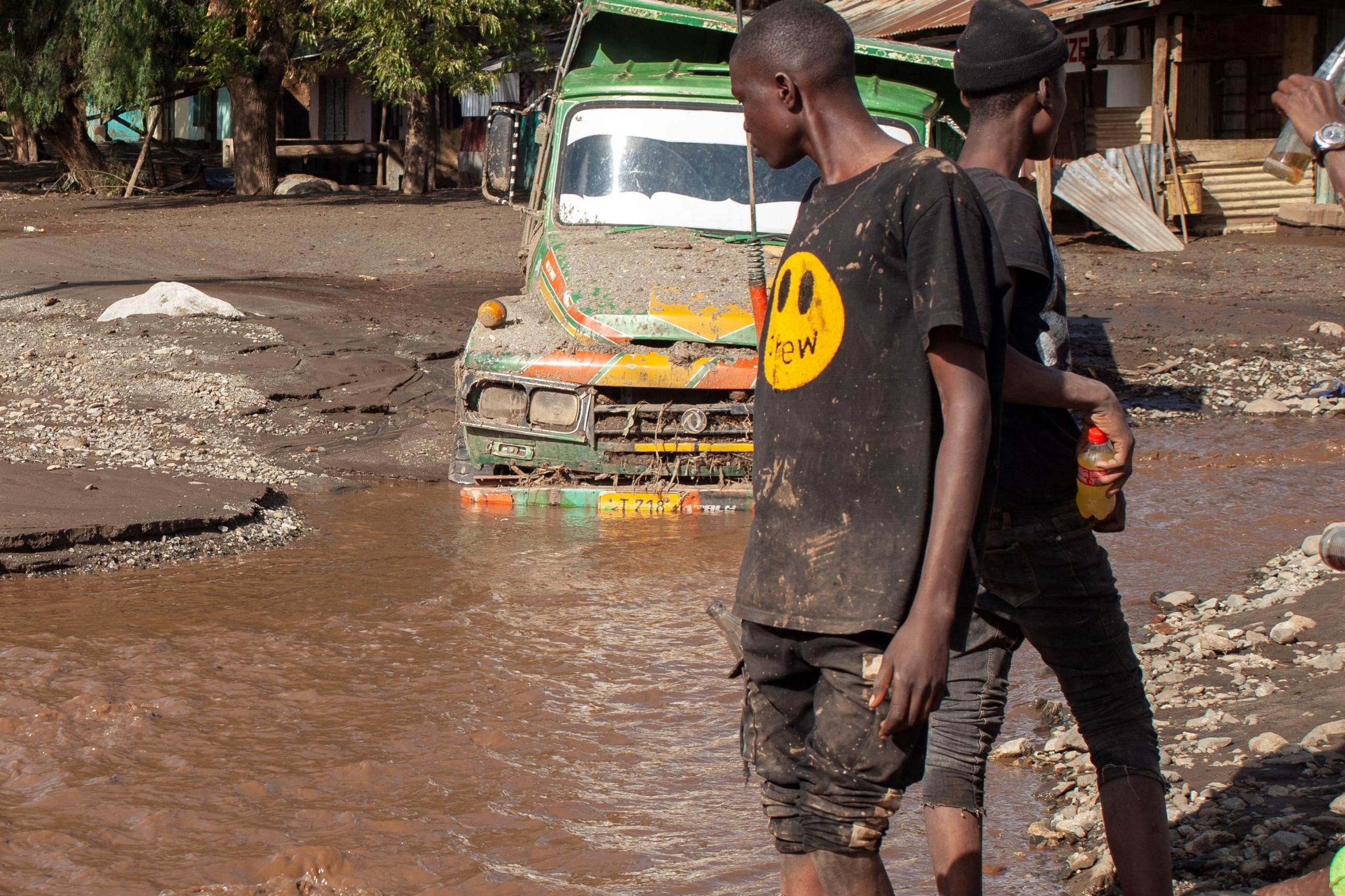 A person looks at a road that was washed away in a flash flood.