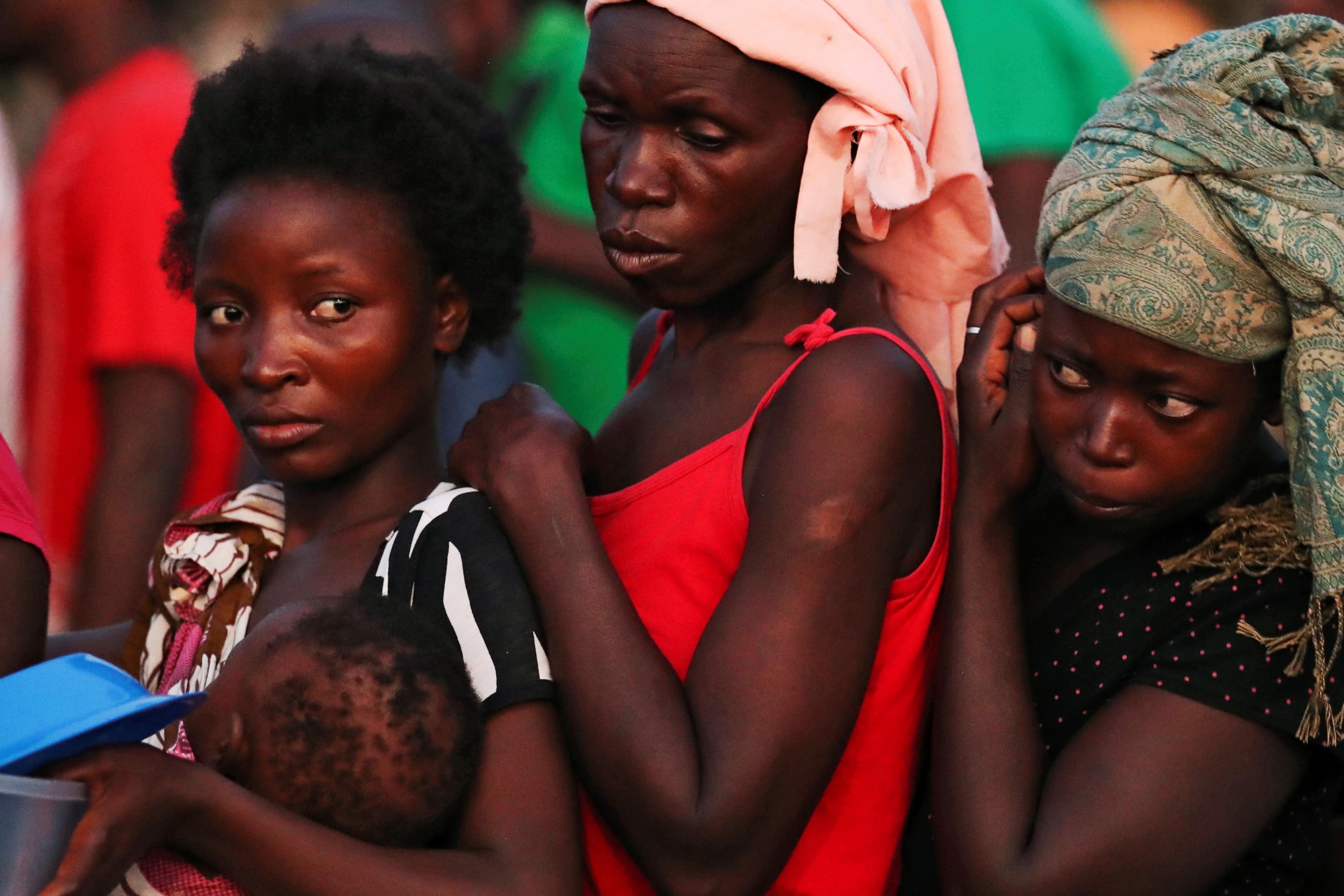 Women wait for food at a camp for people displaced in the aftermath of Cyclone Idai.