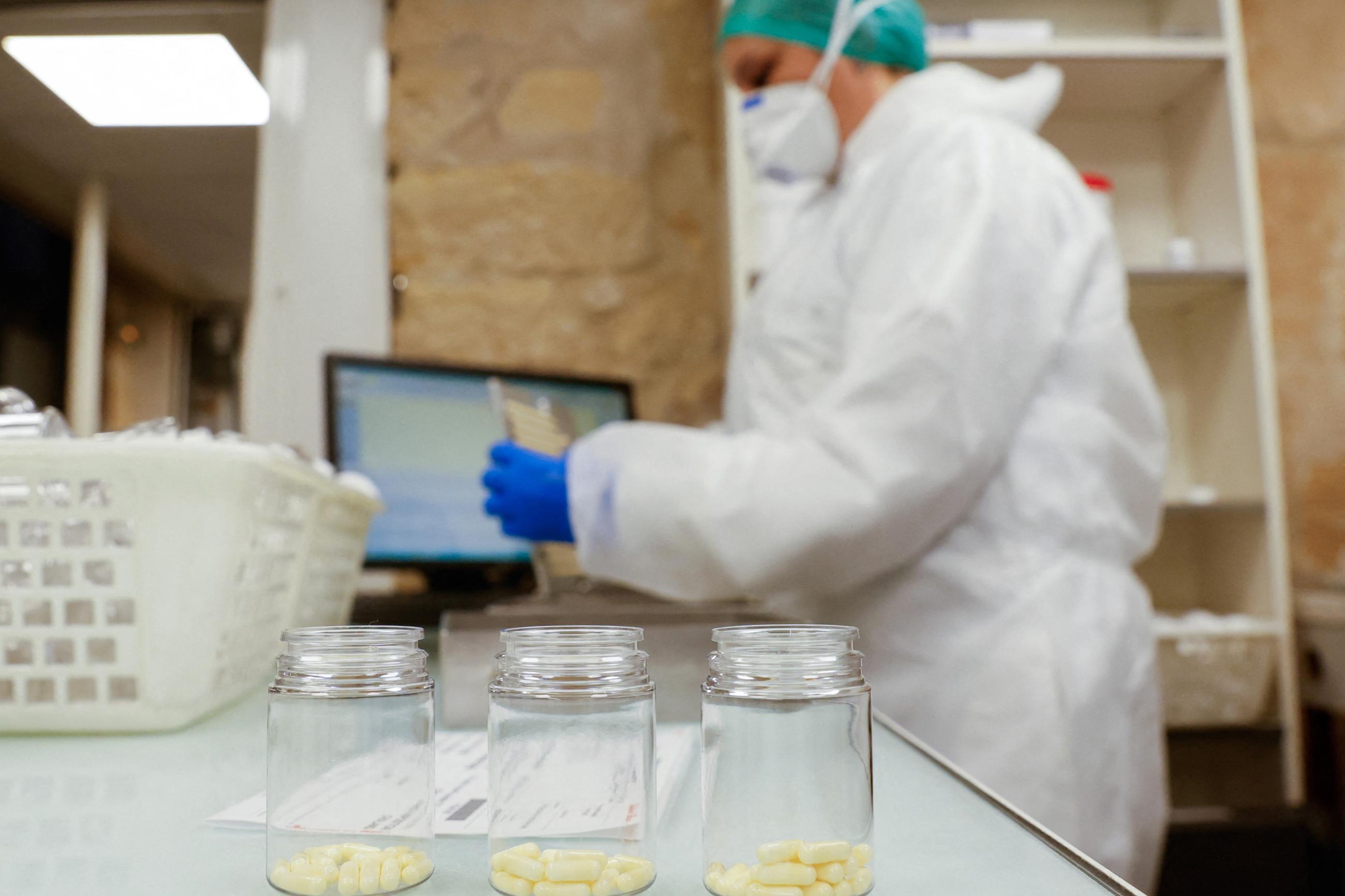 A person works packaging capsules of amoxicillin at the Delpech pharmacy.