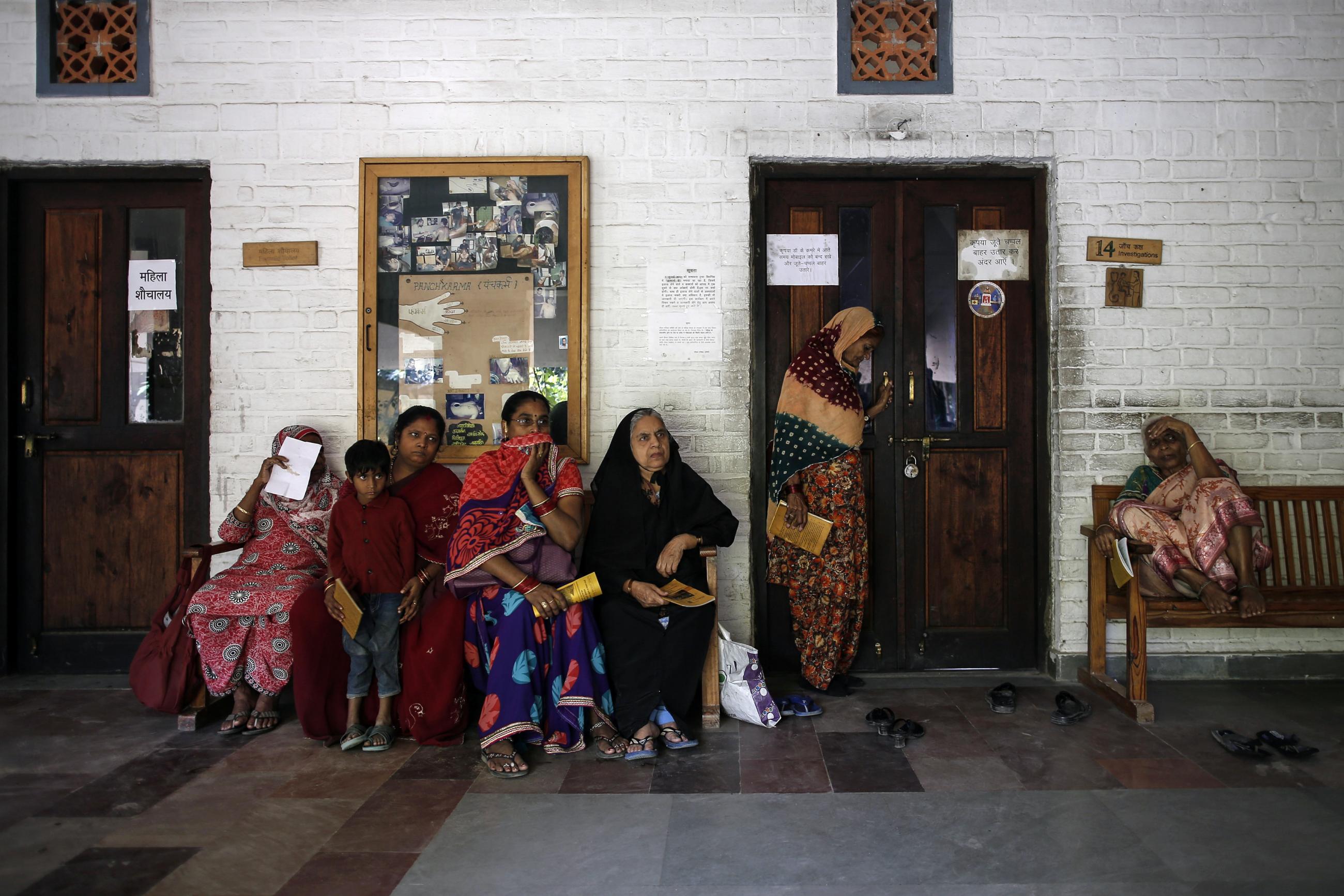 People wait to receive medicine at a clinic.