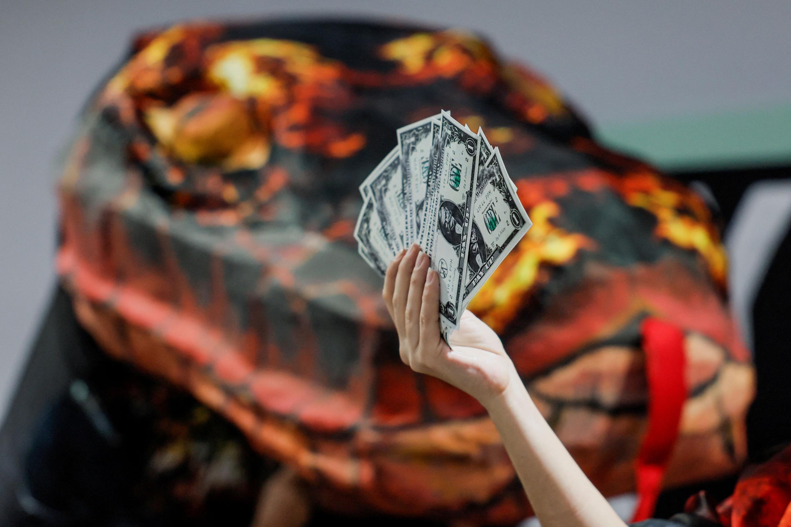an activist holds up fake currency bills